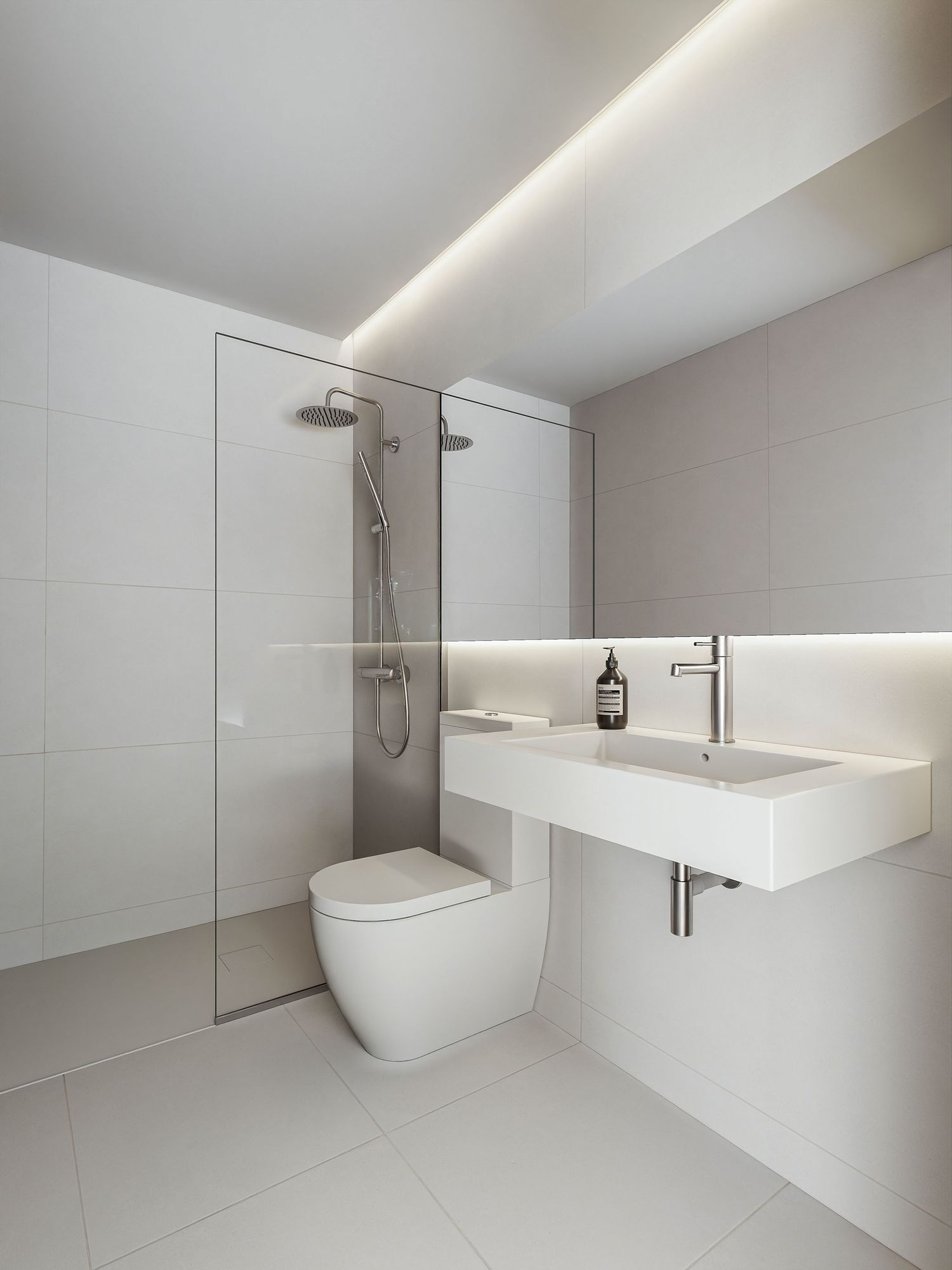 Modern minimalist bathroom interior with white freestanding bathtub, floating vanity, and soft LED accent lighting.