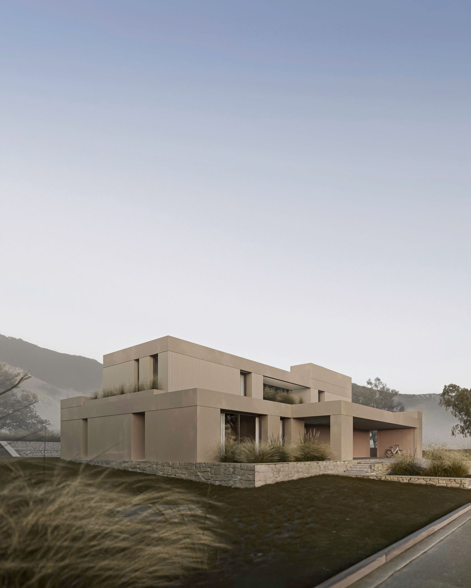 Modern minimalist beige house with geometric architecture set on a hillside at dusk.