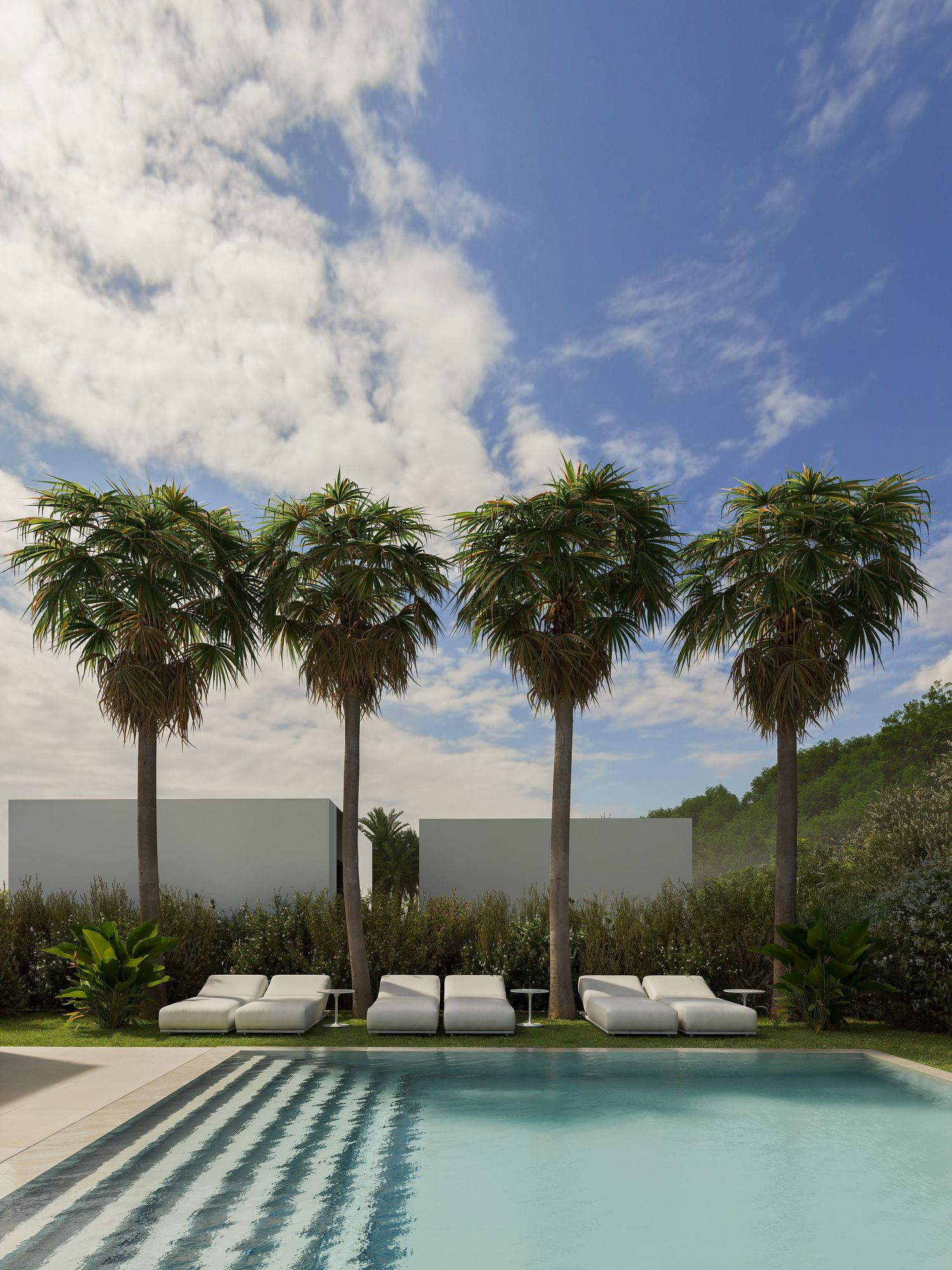 Modern luxury poolside lounge chairs lined up under palm trees against a bright blue sky with white clouds.
