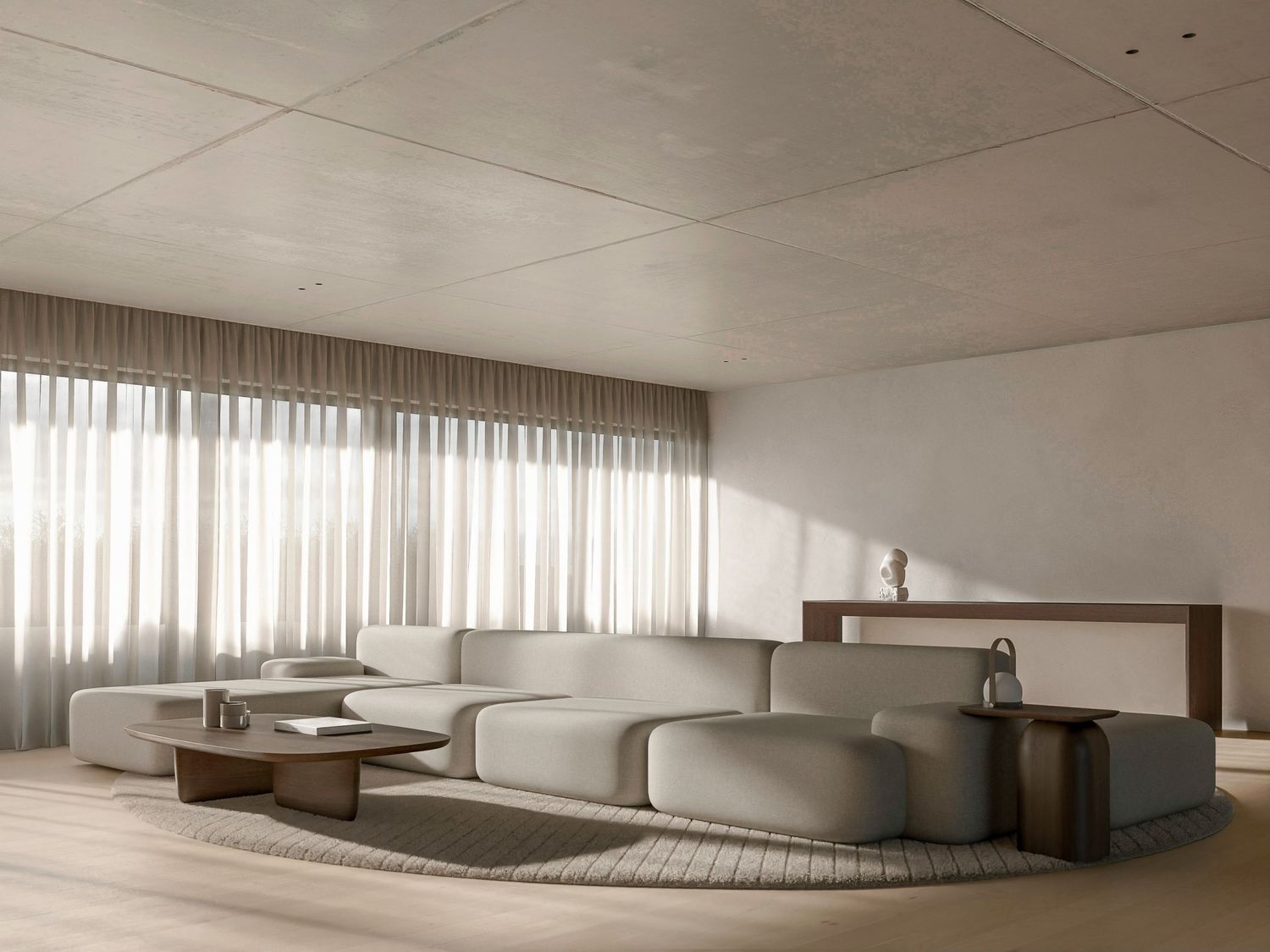 Modern minimalist living room with curved modular white sofa and sheer curtains in a monochromatic neutral palette.
