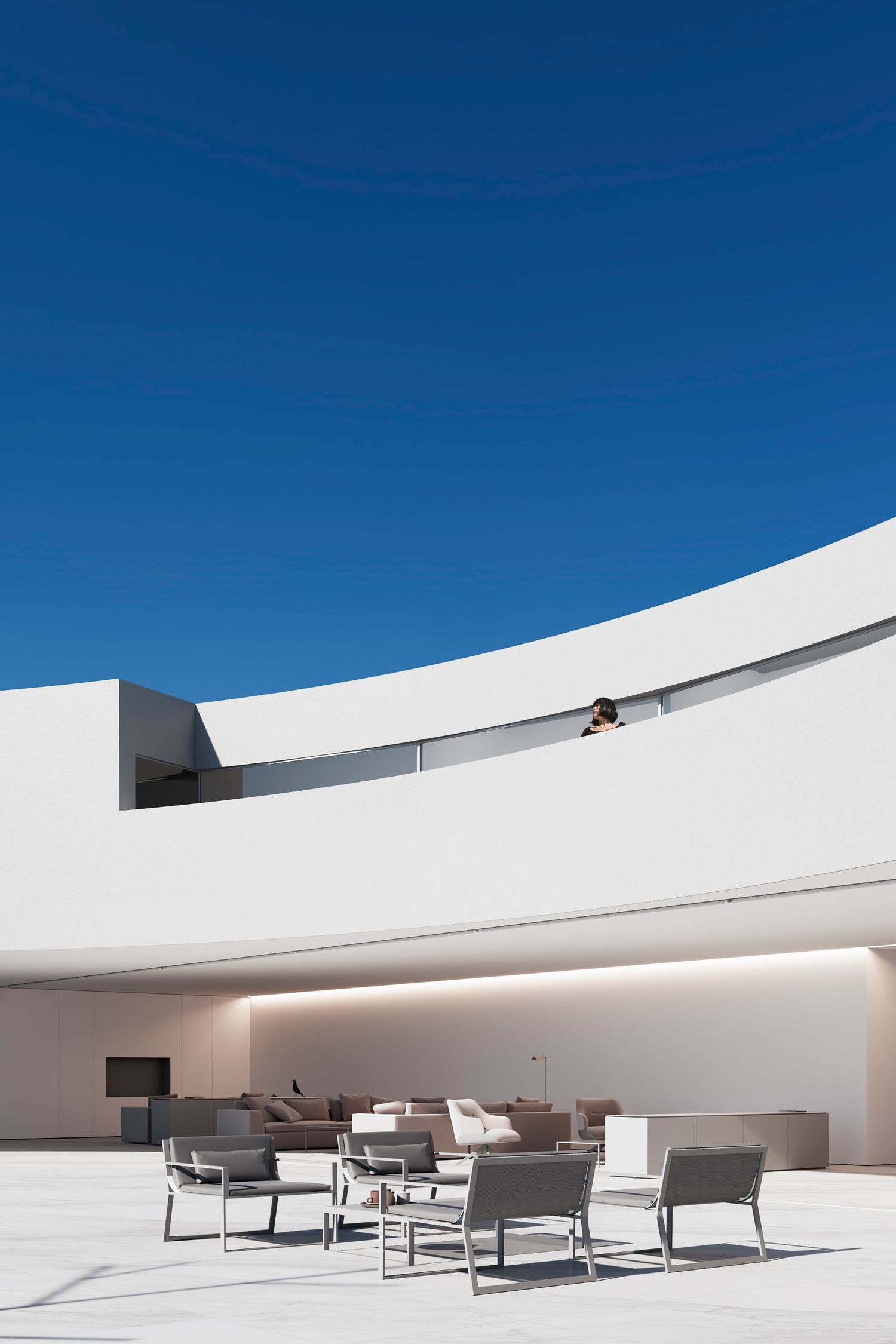 Modern outdoor patio with minimalist white architecture features curved walls and gray lounge furniture under bright blue sky.