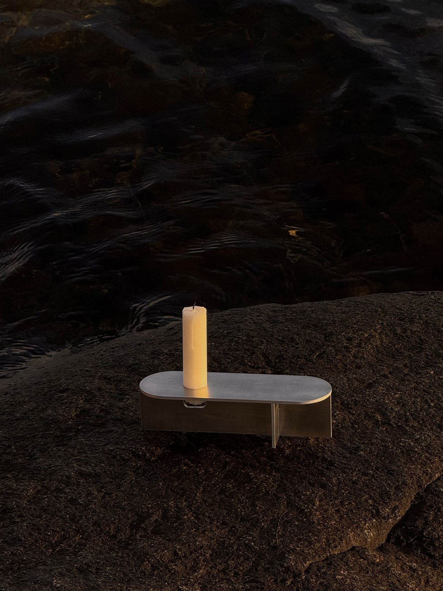 A white candle burns brightly against a dark background in a series of progressive shots showing different angles.