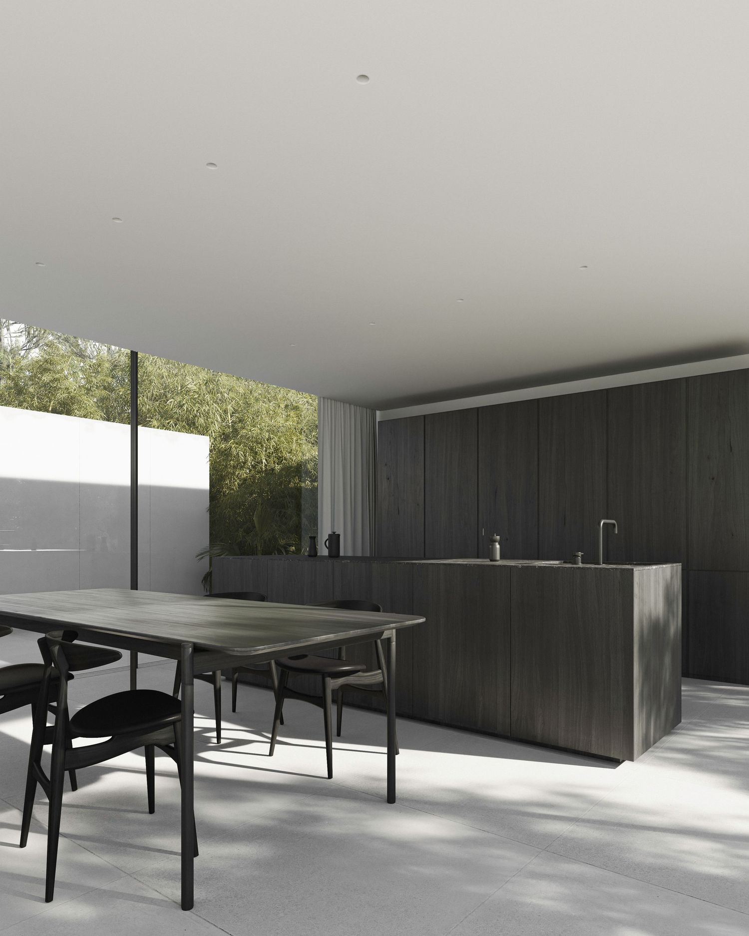 Modern minimalist kitchen and dining area with dark cabinetry, concrete floors and floor-to-ceiling windows overlooking greenery.