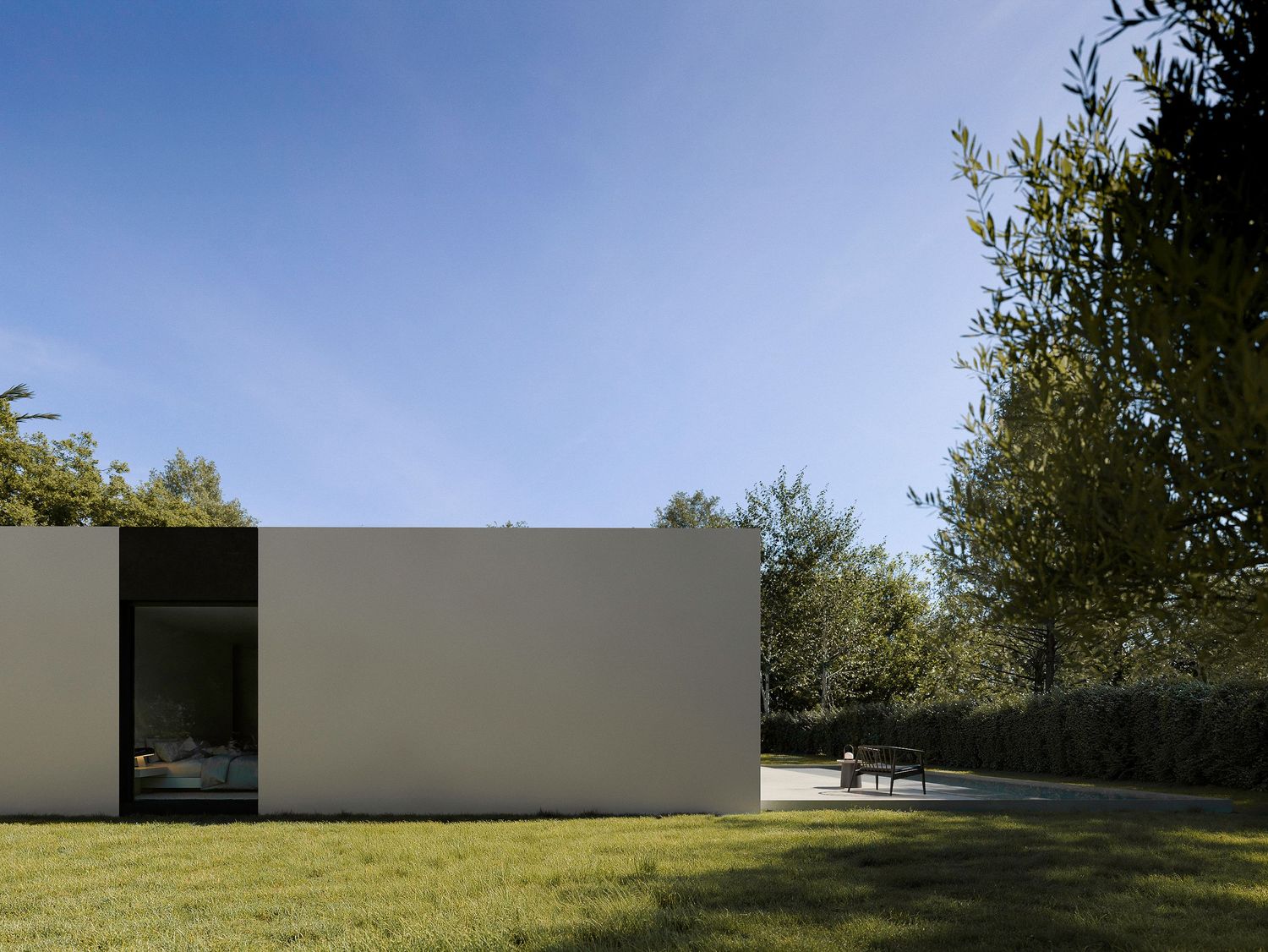Stark white modernist structure with dark glass opening set in manicured garden setting.