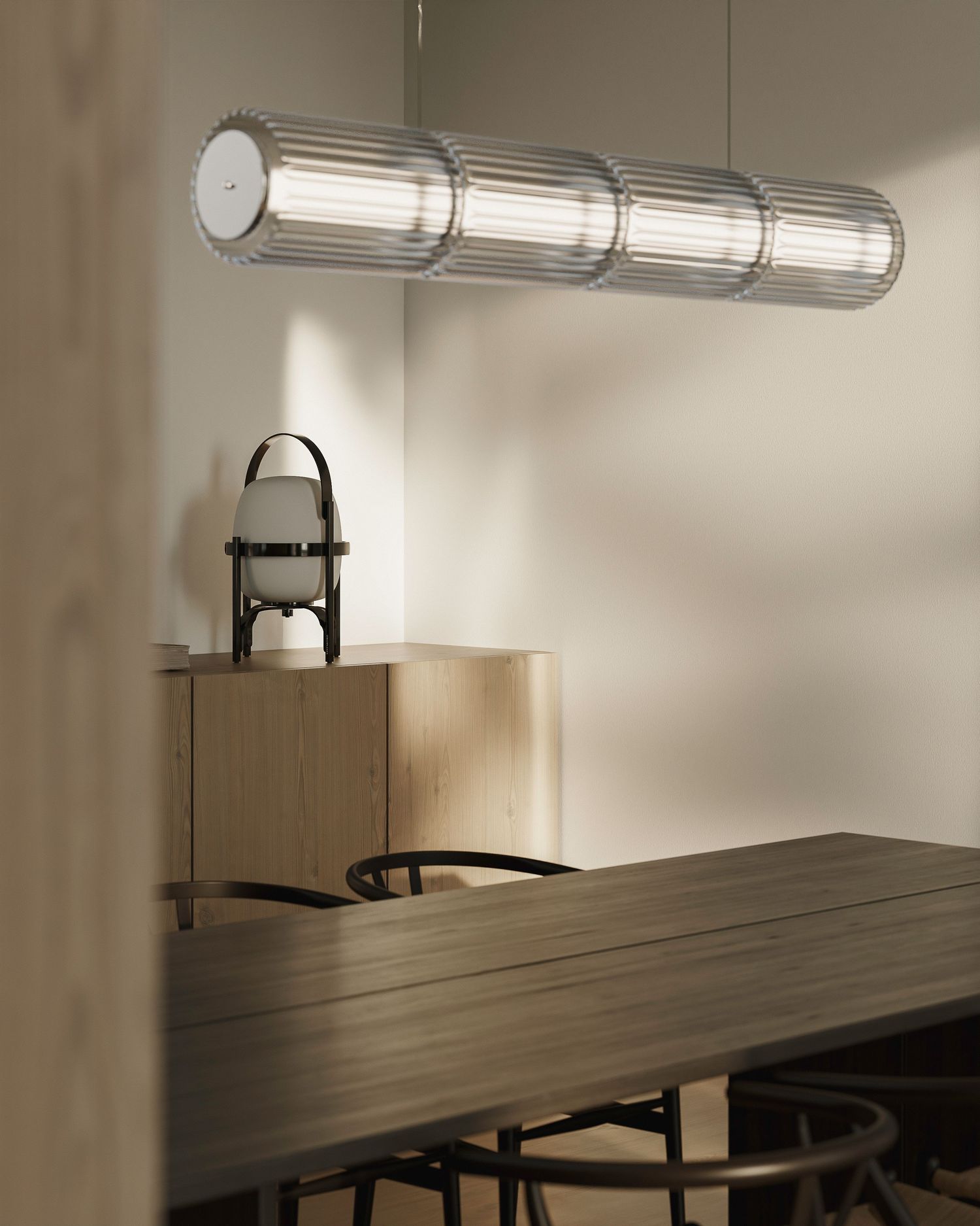 Sleek modern light fixture mounted on wall above wooden table casting ambient illumination in minimalist room.