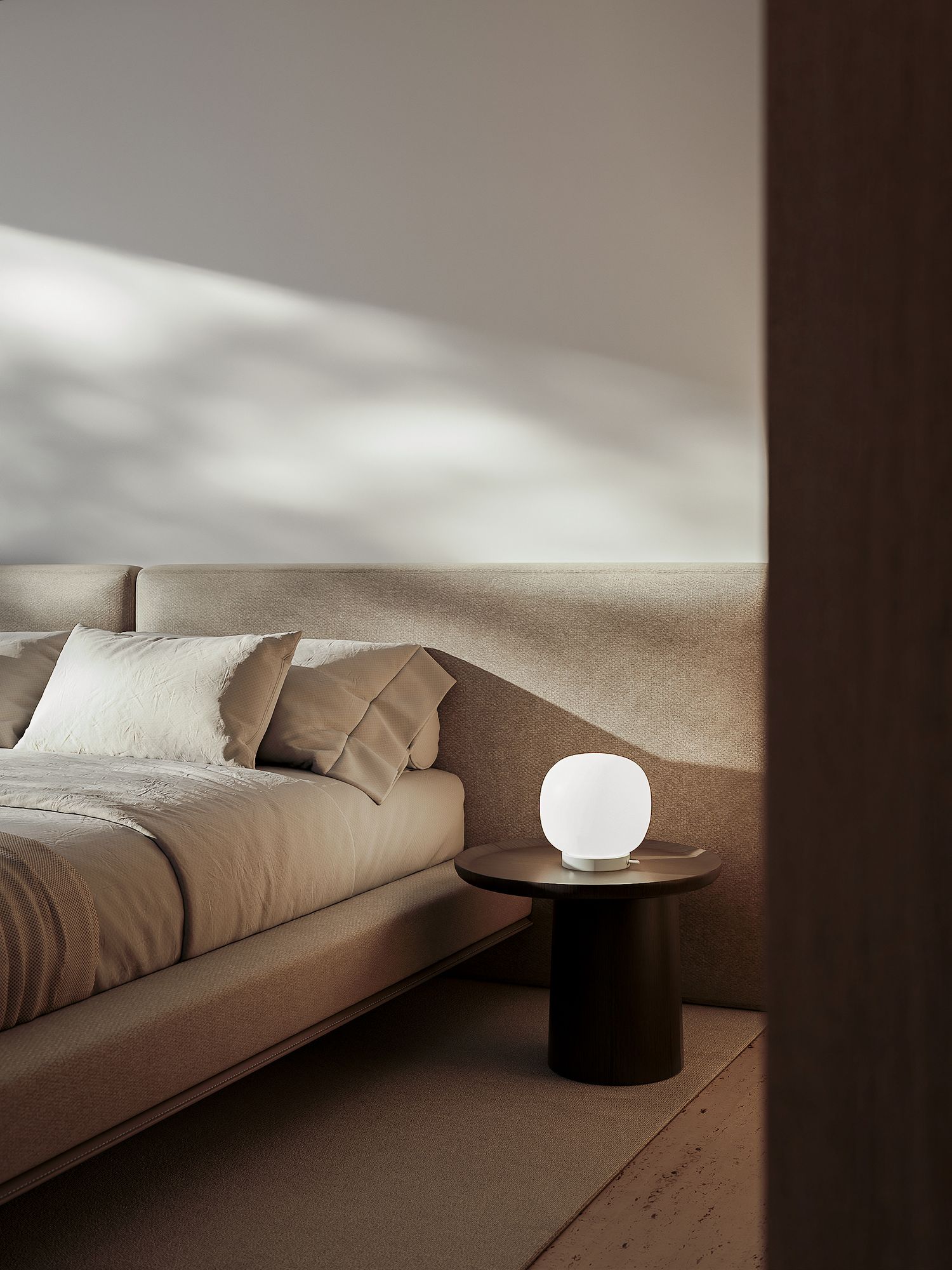 Minimalist bedroom interior with beige bedding and round glowing table lamp on black side table against neutral wall.