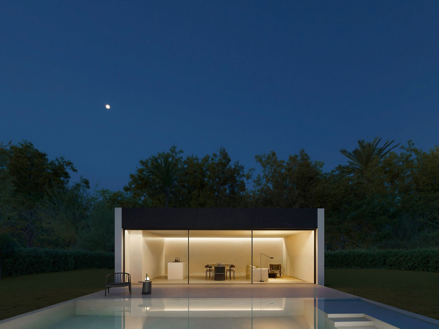 Sleek modern house with large glass windows illuminated at night and reflecting in an infinity pool.