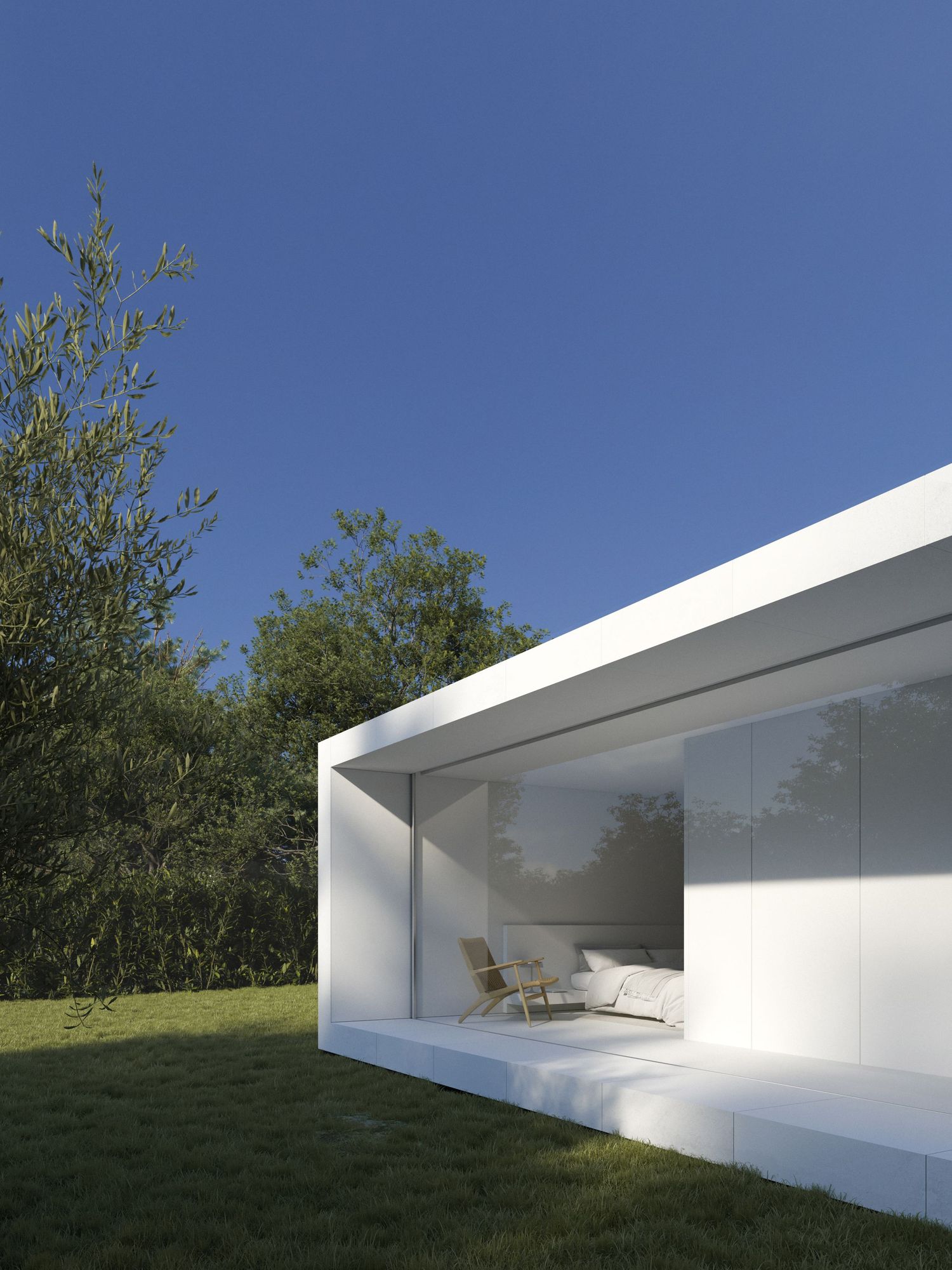 Modern minimalist white building with glass windows and sleek overhang creates a serene outdoor space against blue sky.