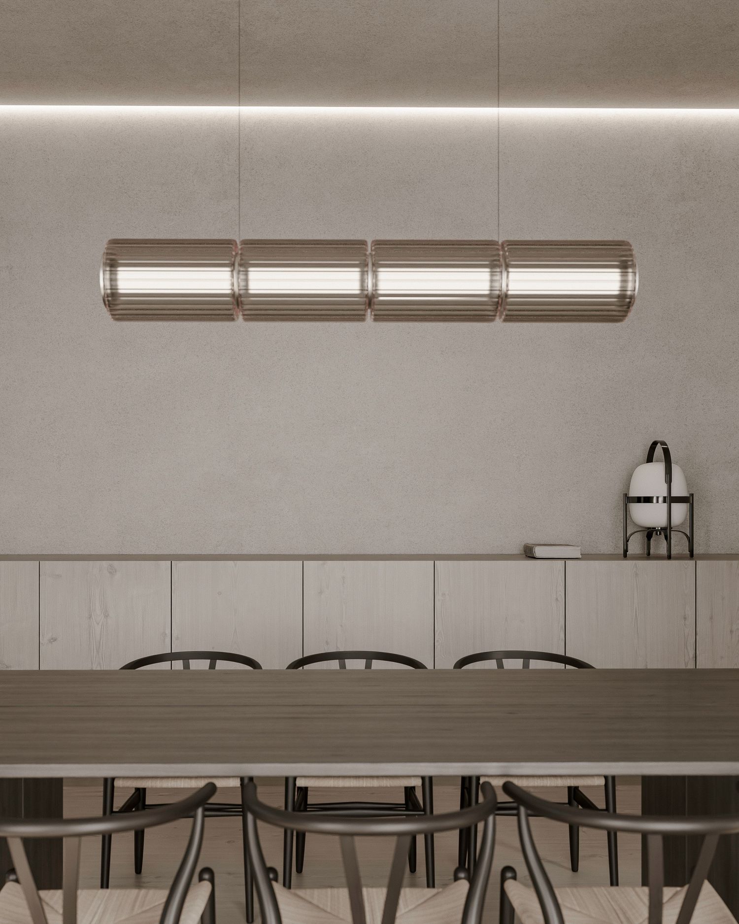 Modern minimalist dining room with cylindrical pendant light fixture, wooden table and chairs in monochromatic gray tones.