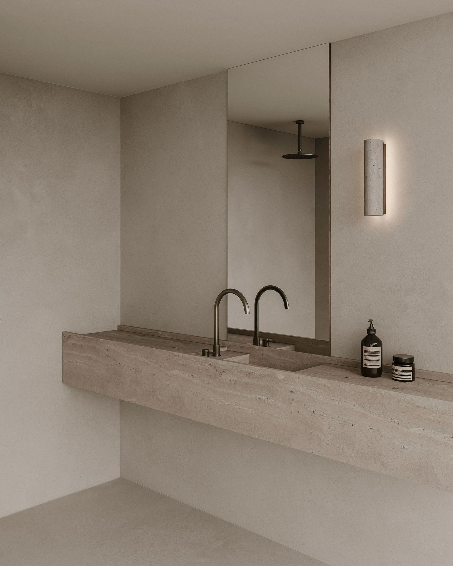 Minimalist modern bathroom with floating stone vanity, black faucets, mirror, and wall sconce in neutral beige tones.