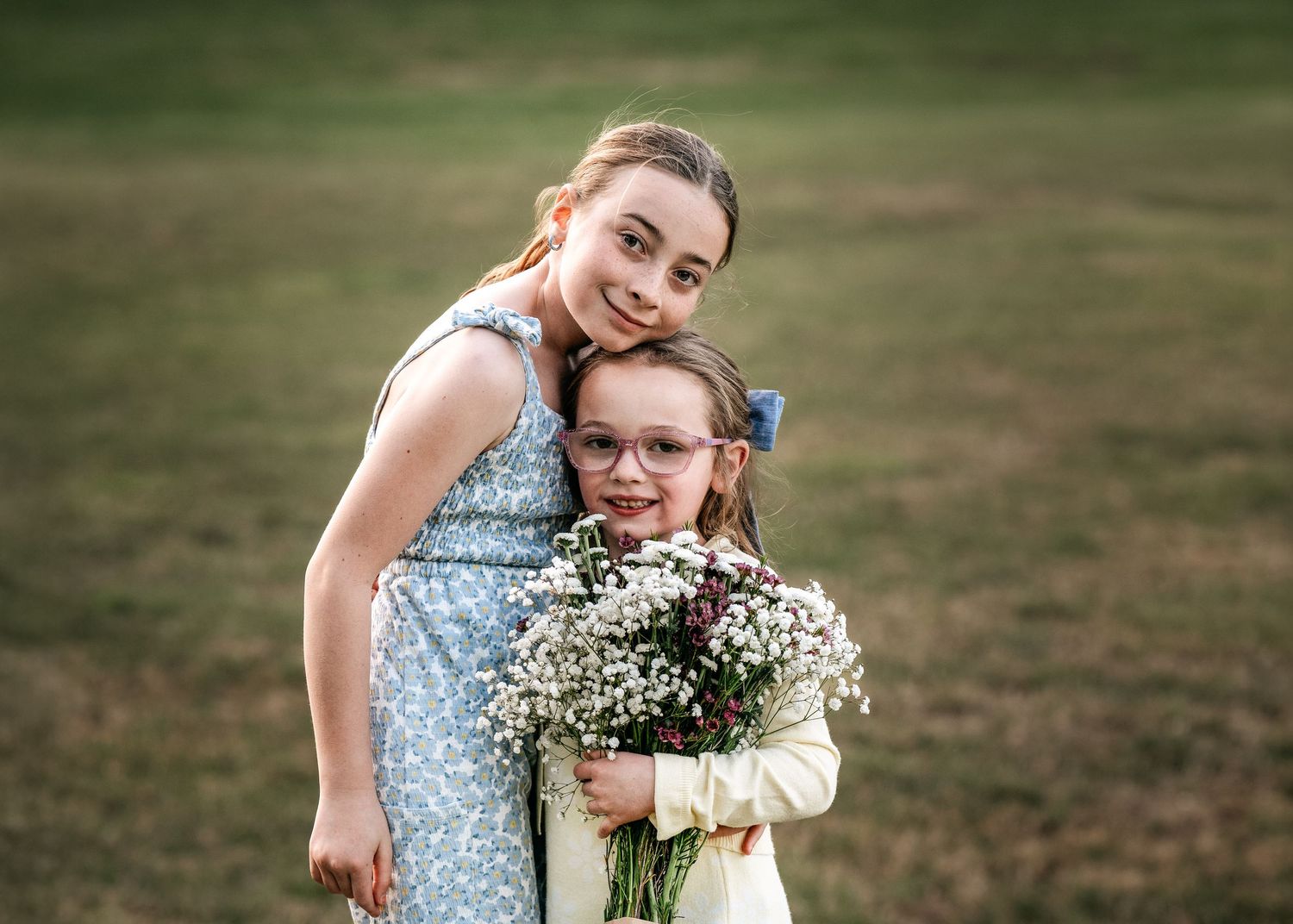 Two girls in dresses pose outdoors during their Mommy & Me portrait session in Wayne, PA.