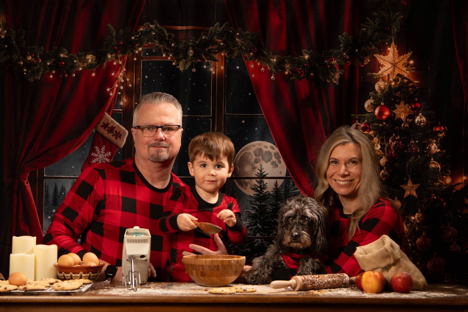 Christmas decorations and baking scene with red curtains and illuminated tree in background.