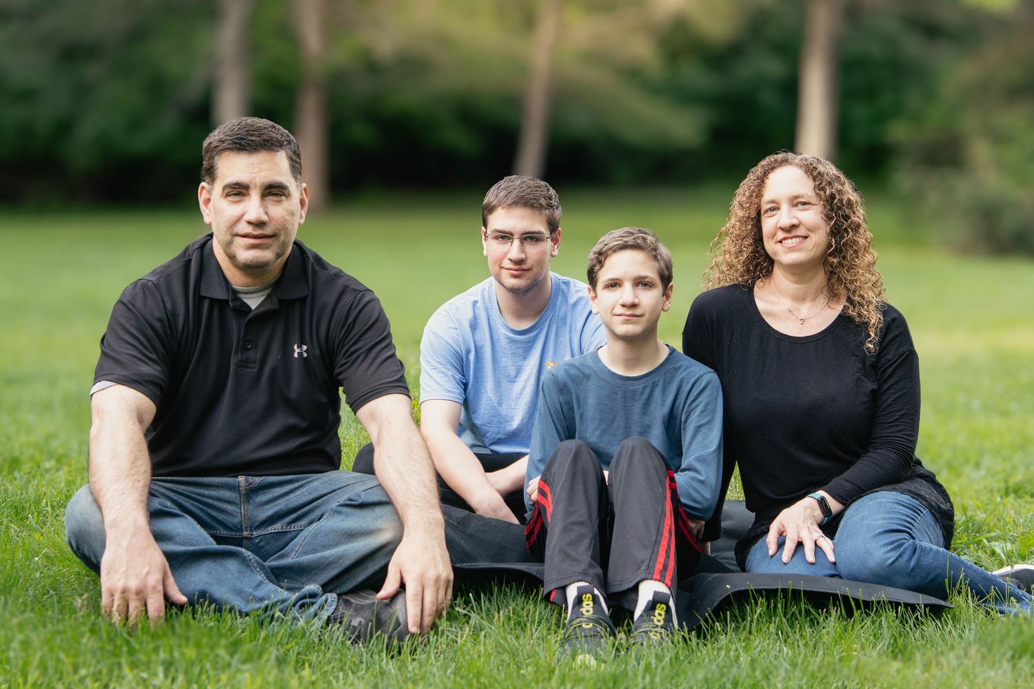 Family members lounging on grass during an outdoor photo session.
