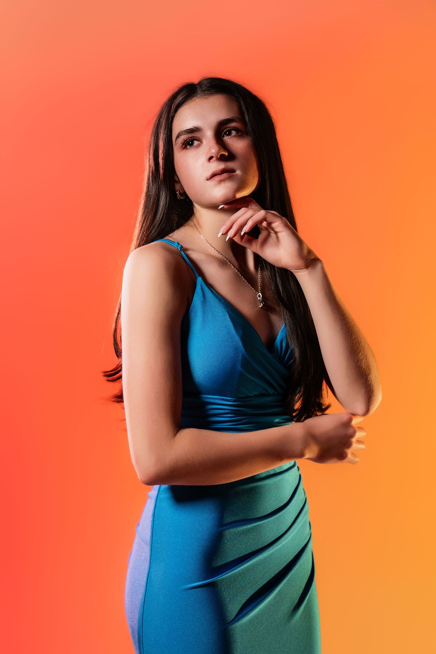A high school senior posing in a blue dress during her glam portrait studio session on the Main Line, PA.