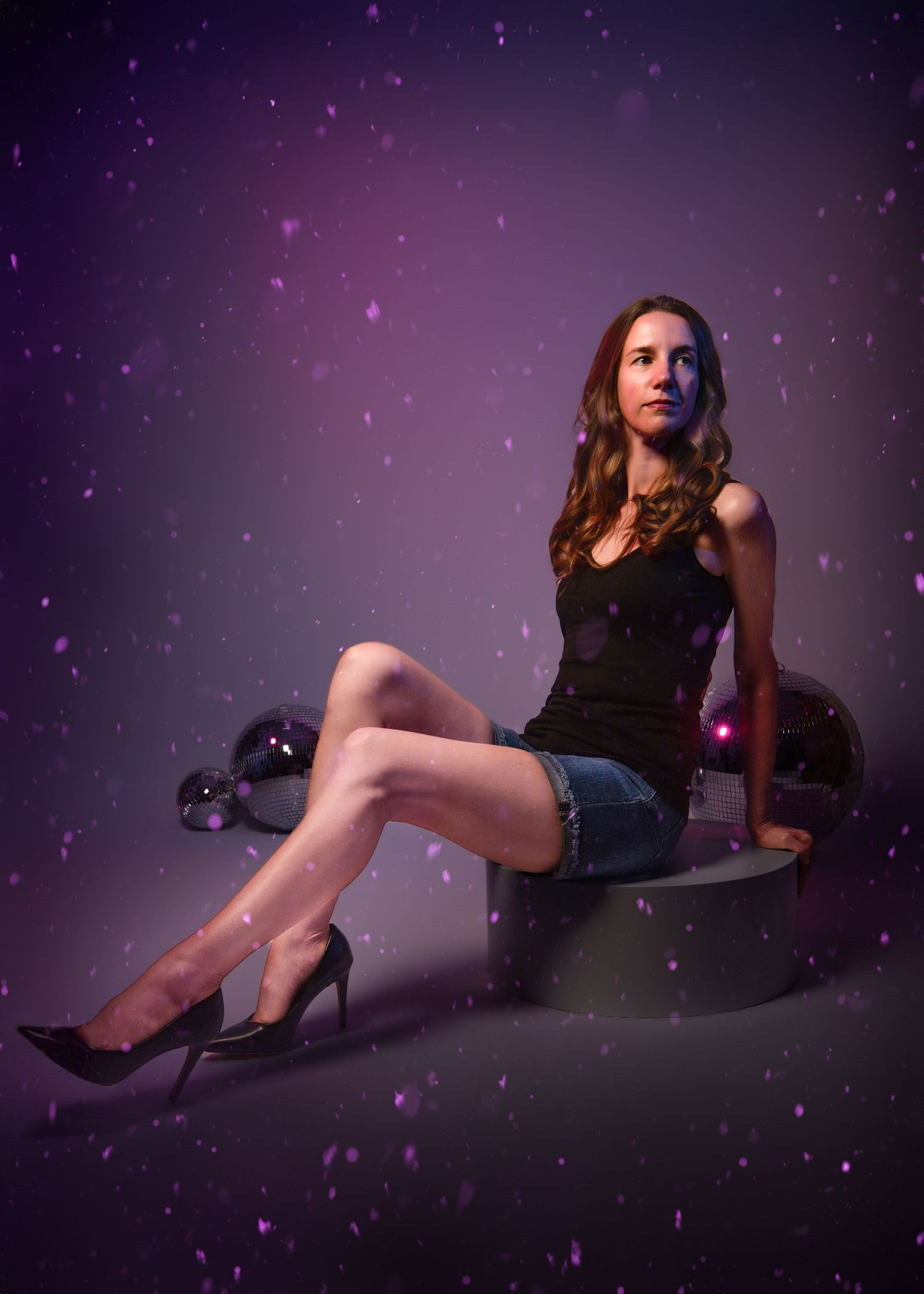 Creative women's studio portrait with disco balls and a dreamy purple bokeh background during her studio glam session on the Main Line, PA.