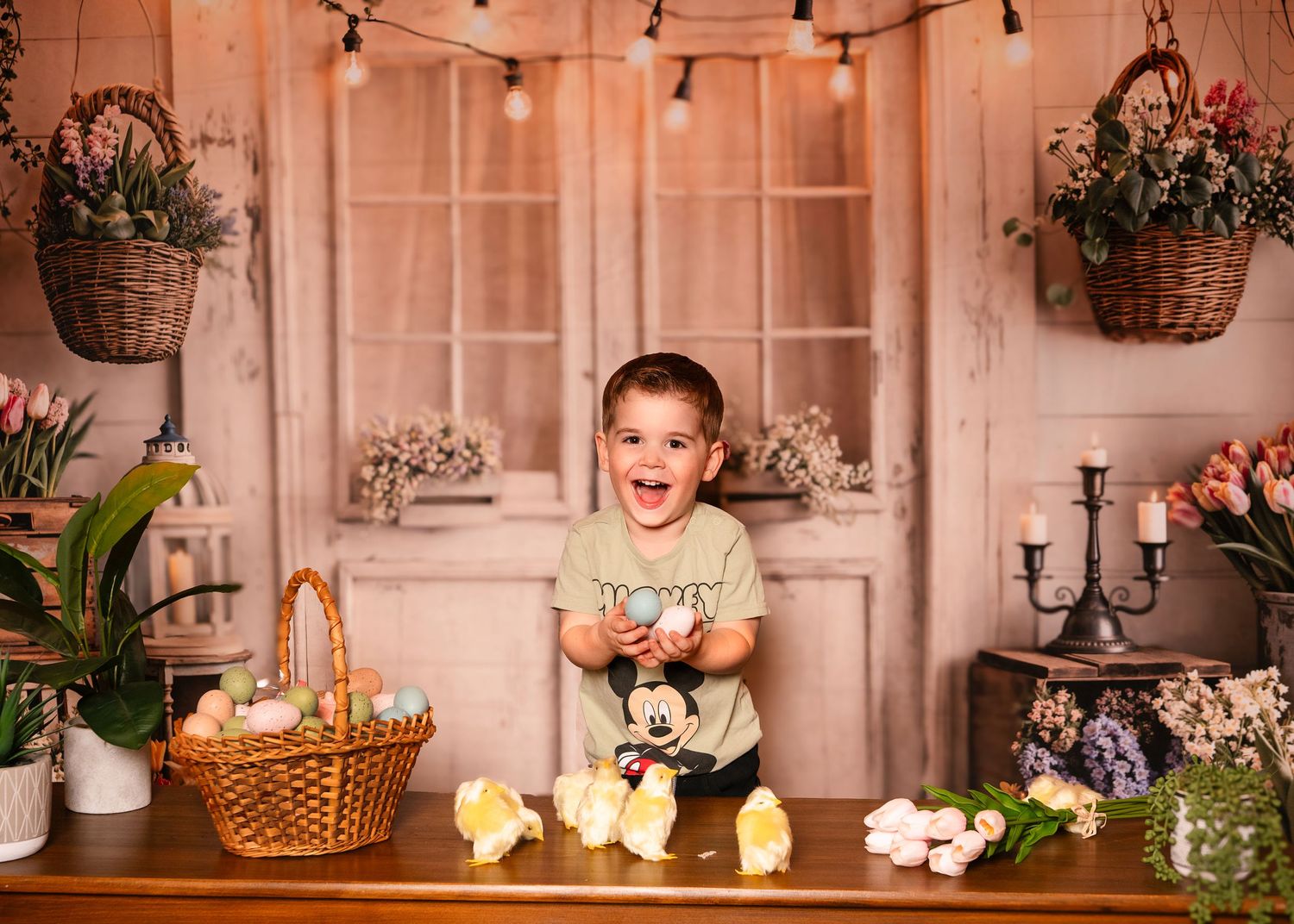 Joyful toddler boy laughing at Easter-themed photo shoot on the Main Line, PA.