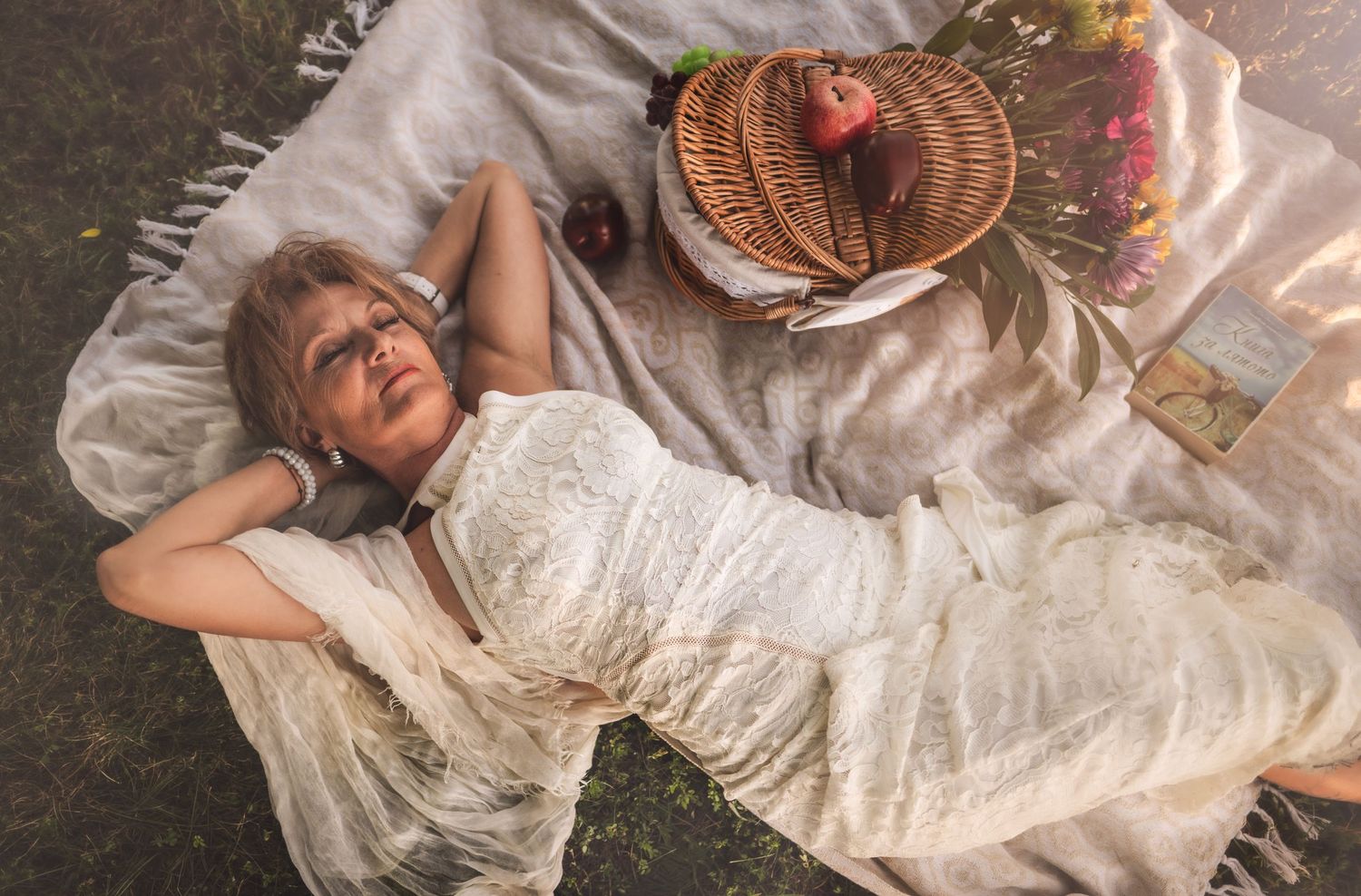 A dreamy picnic scene with a white lace dress and wicker basket on a blanket in soft lighting.