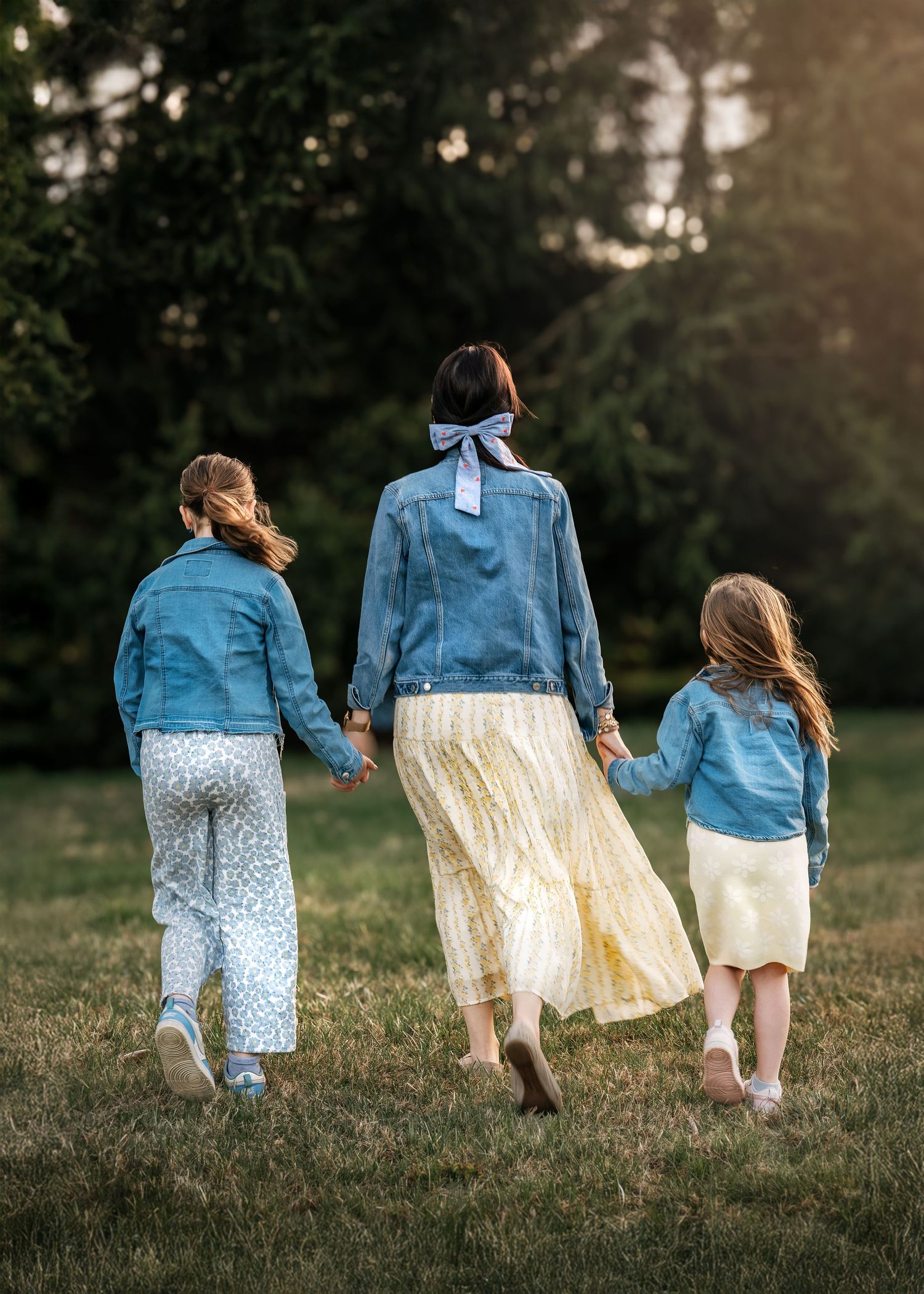 A mother and two daughters walking hand in hand during their Mommy & Me portrait session on the Main Line, Pennsylvania.