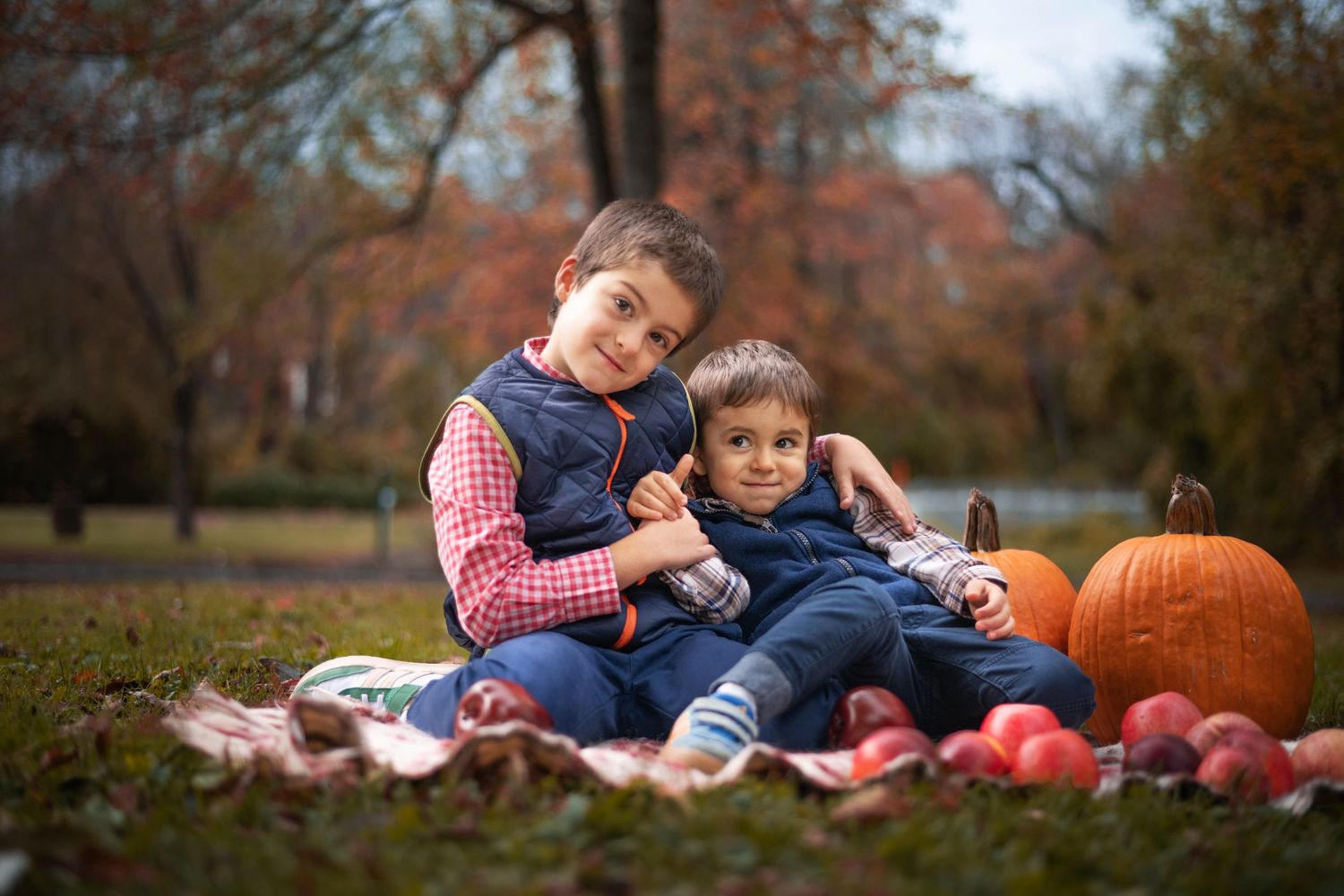 Family autumn photo session with pumpkins and fall foliage.