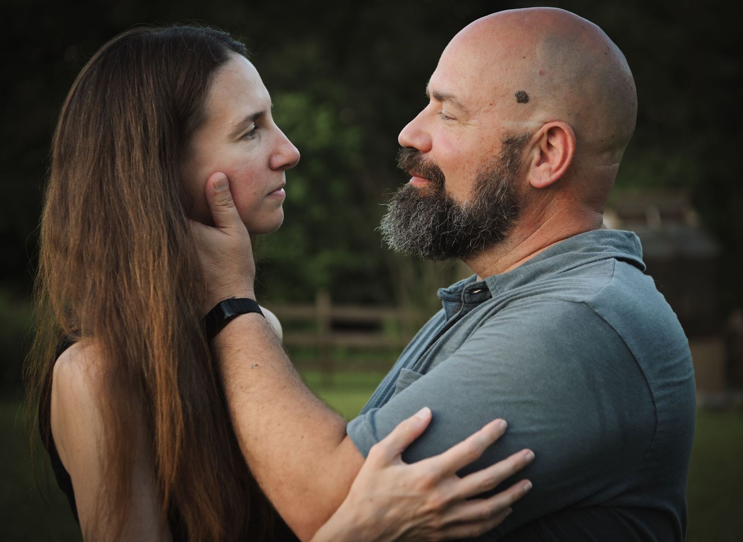 Couple embraces tenderly during outdoor photo session at dusk.