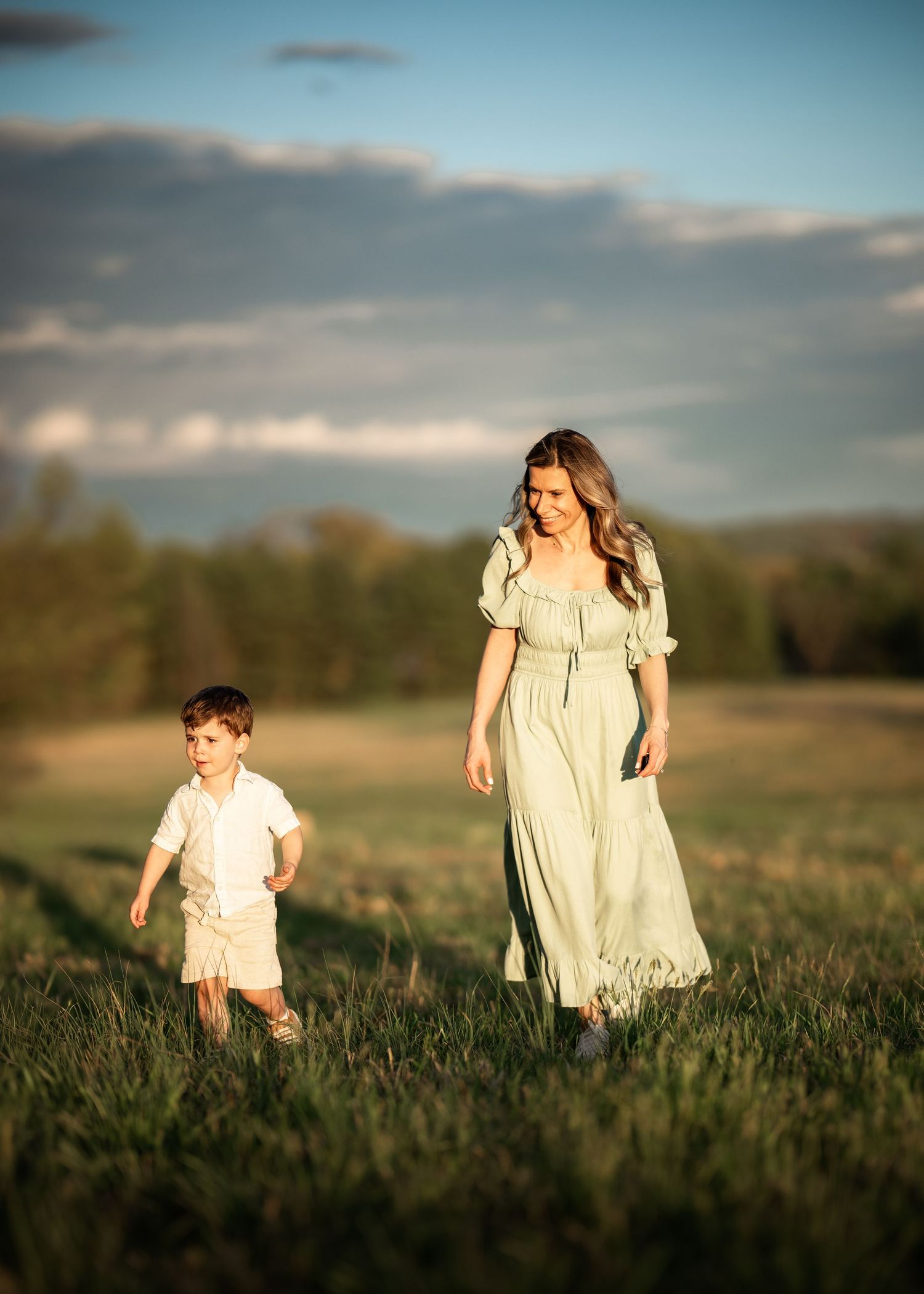 Mother and son walking together at golden hour during Mommy & Me photography session near Wayne, PA.