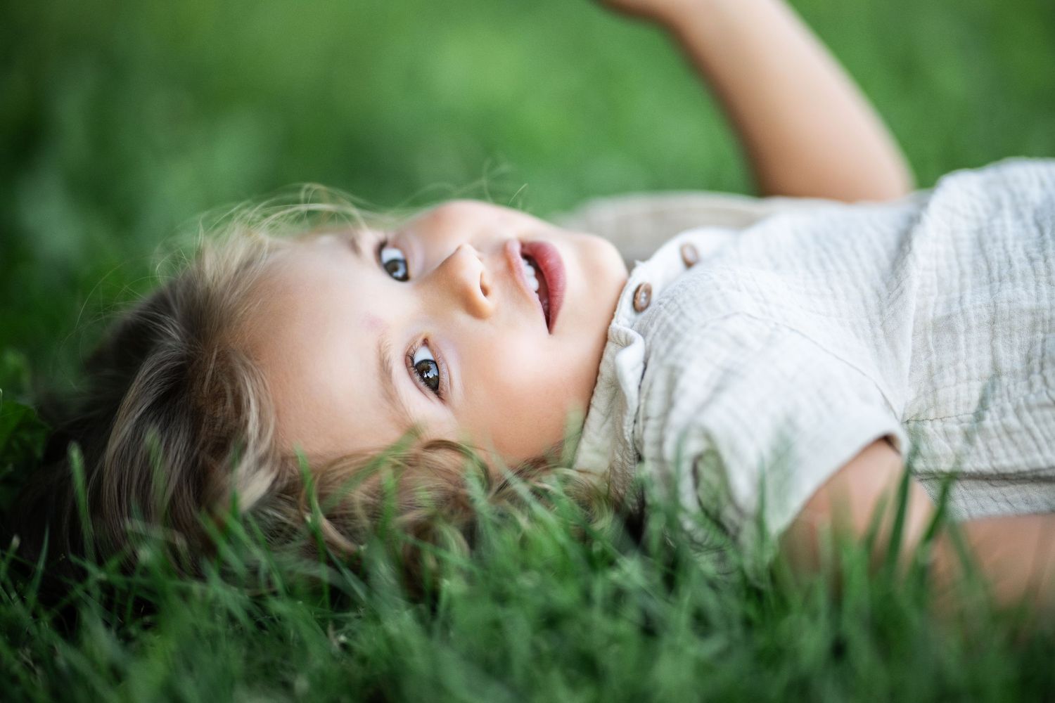 A happy toddler with blue eyes posing during his Mommy & Me portrait session.