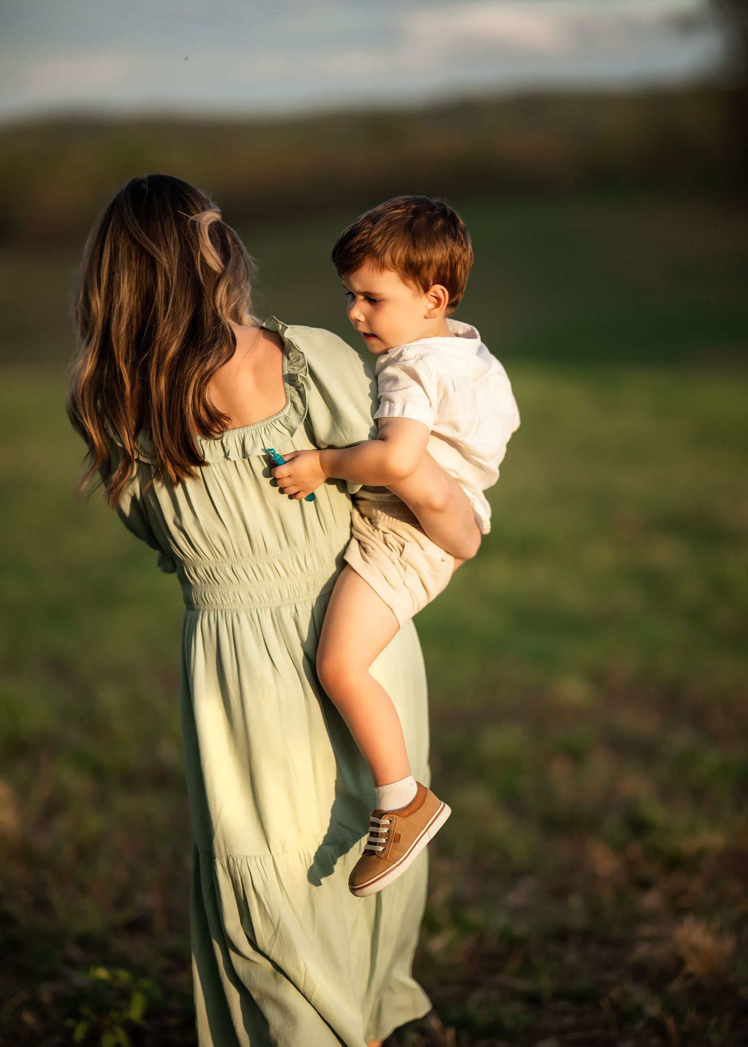 Mommy & Me portrait of mother holding her young son in a sunlit field on the Main Line, PA.