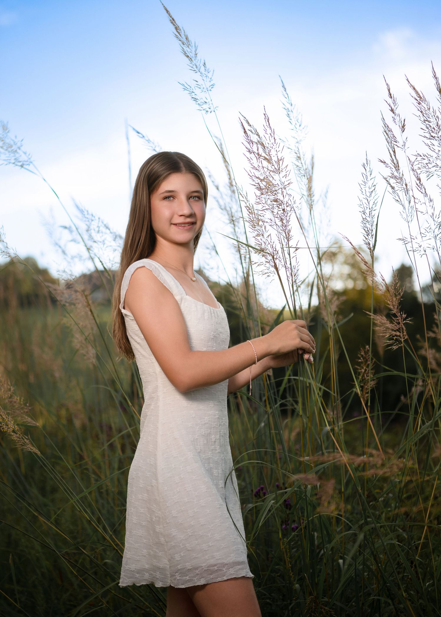 High school senior portrait among tall grasses during an outdoor senior photography session on the Main Line, PA.