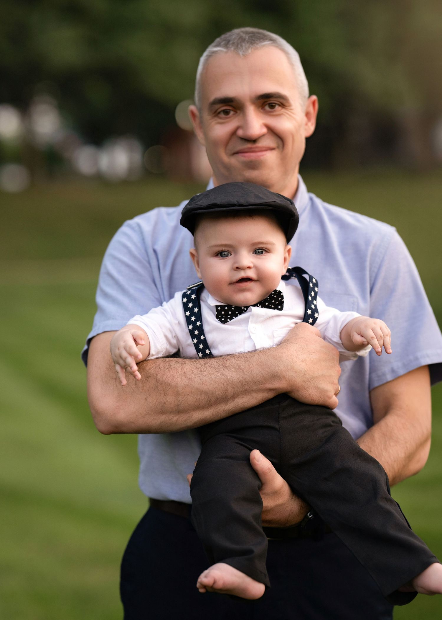 Father holding baby during an outdoor family portrait session near Wayne, PA.