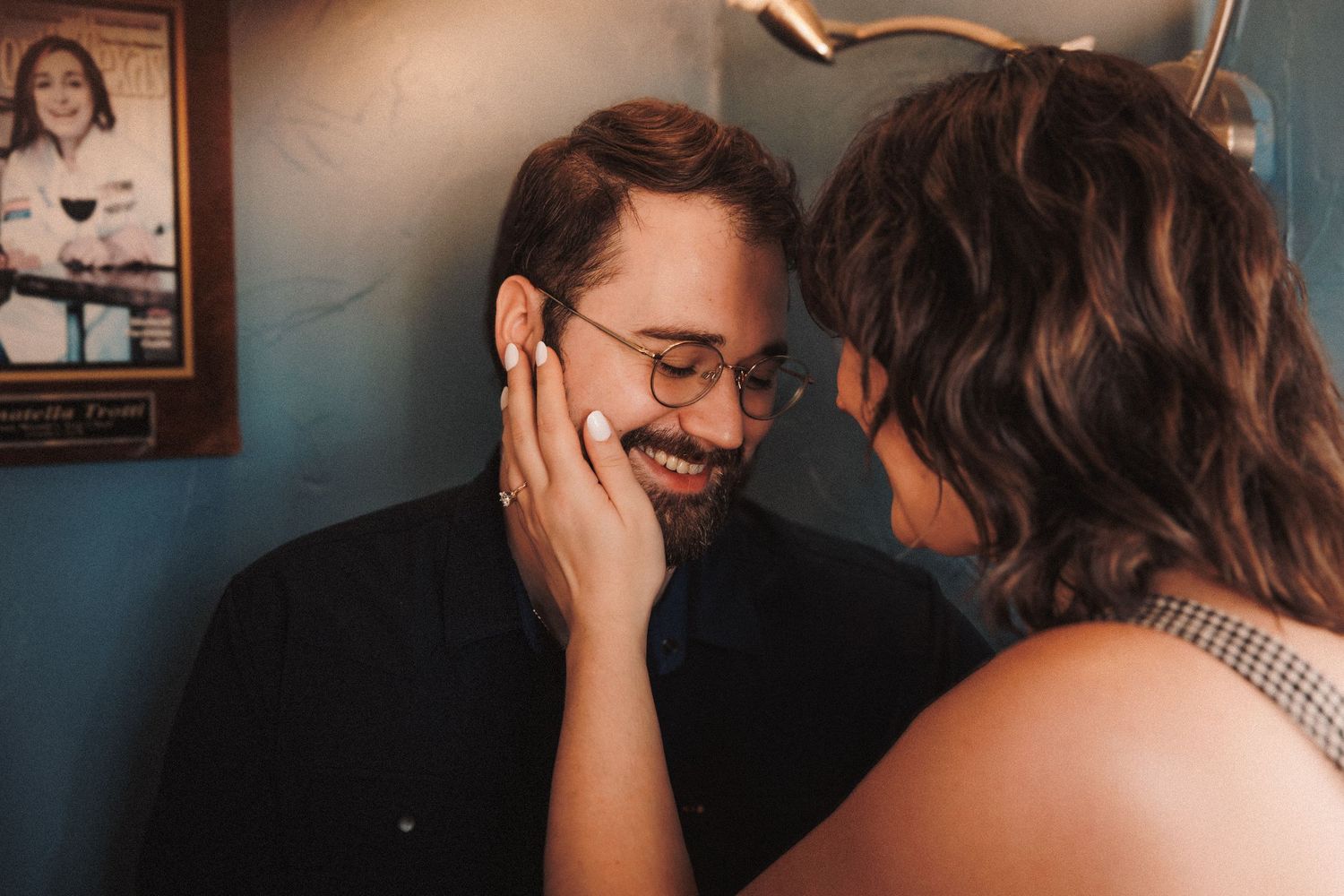 A couple shares an intimate romantic moment while embracing in a dimly lit setting.
