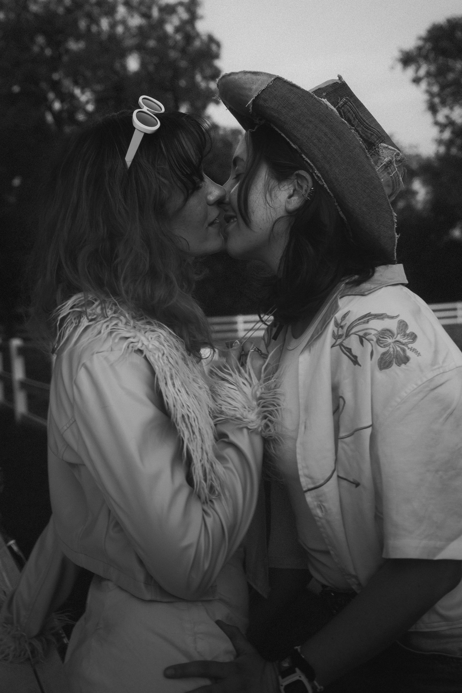 A romantic black and white photo sequence shows a couple sharing a tender kiss in an outdoor setting.