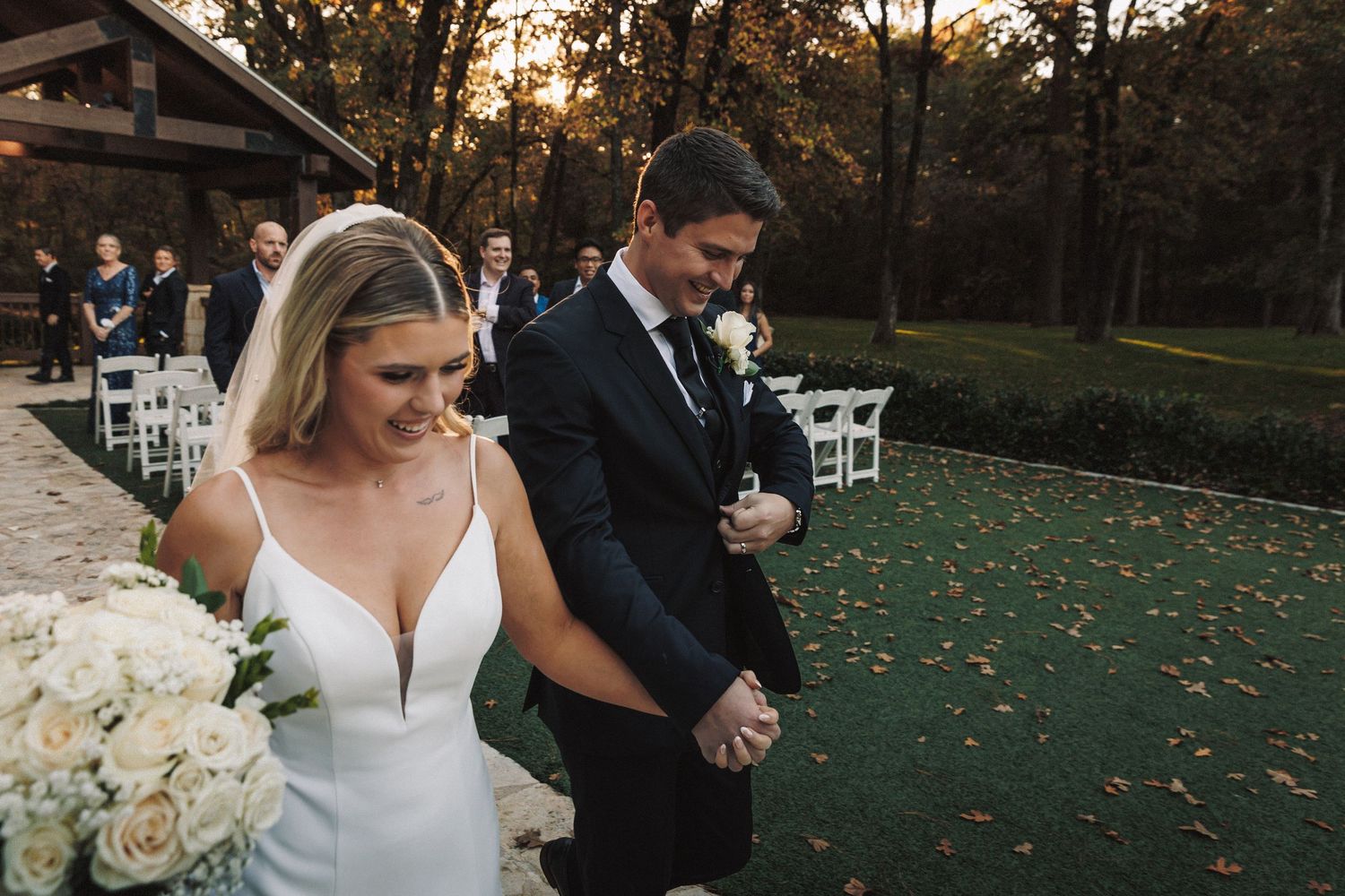 Bride and groom walking hand in hand down the aisle after their outdoor wedding ceremony.