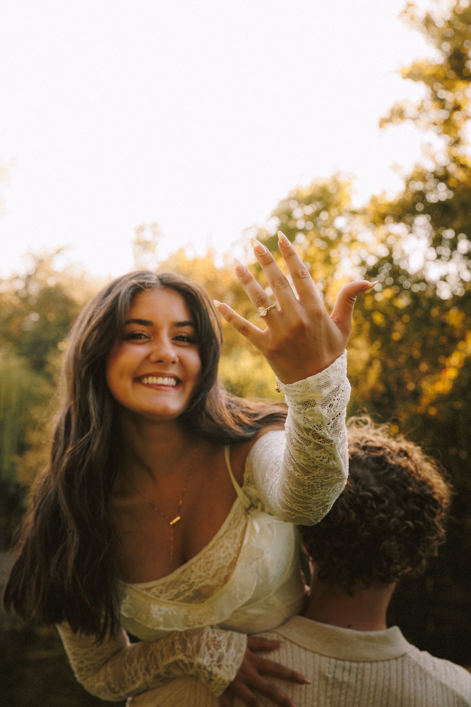 A joyful moment captured showing a ring in golden sunset light.