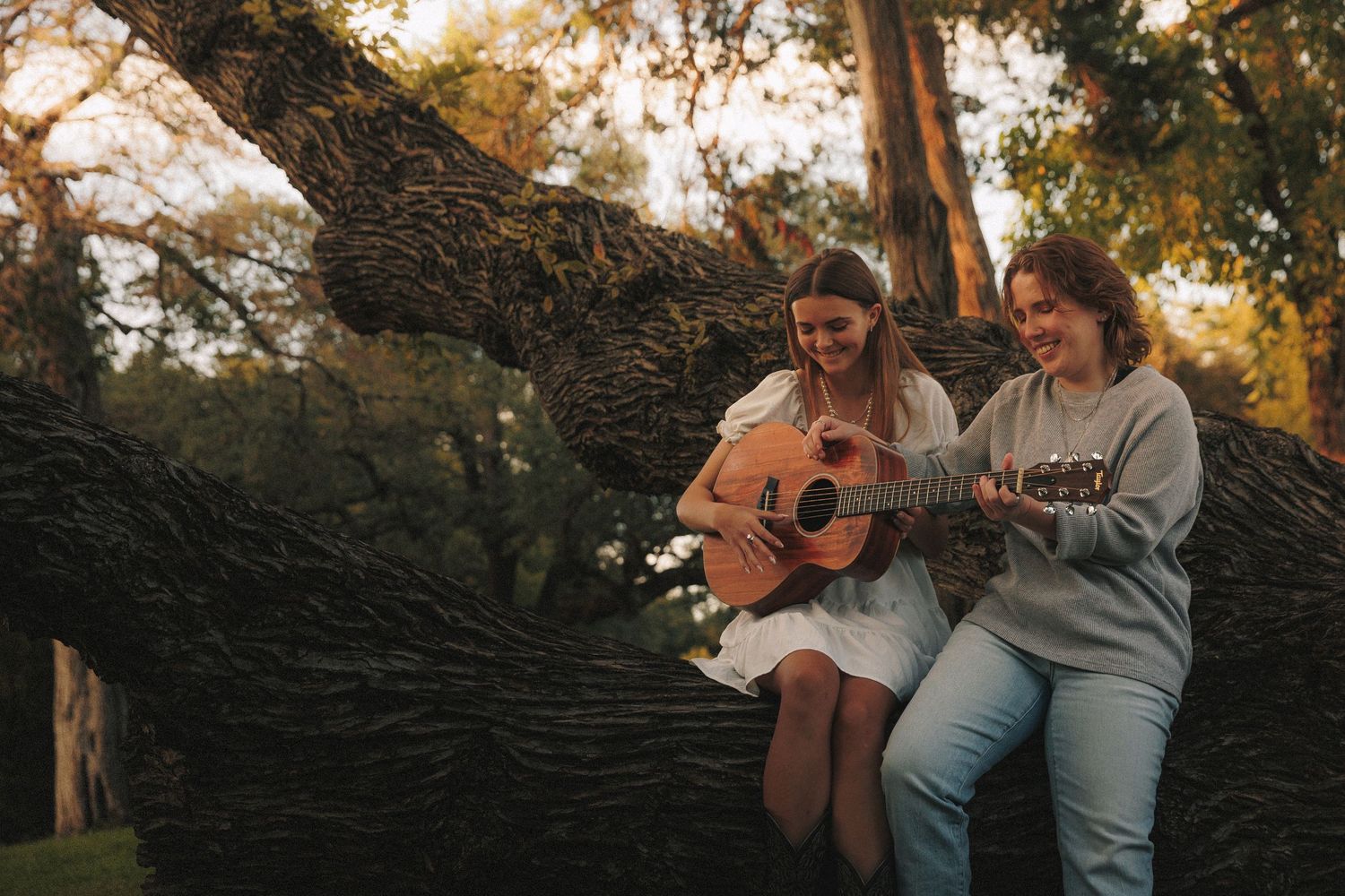 Couple embraces and laughs together during golden hour sunset photoshoot in nature setting.