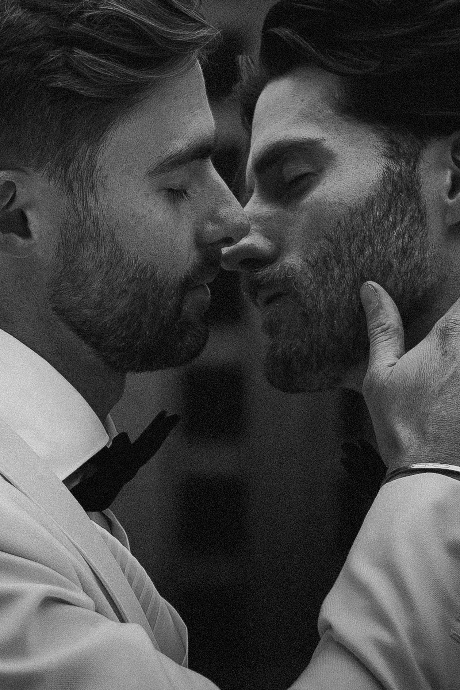 Intimate black and white close-up of two grooms nearly kissing on their wedding day.