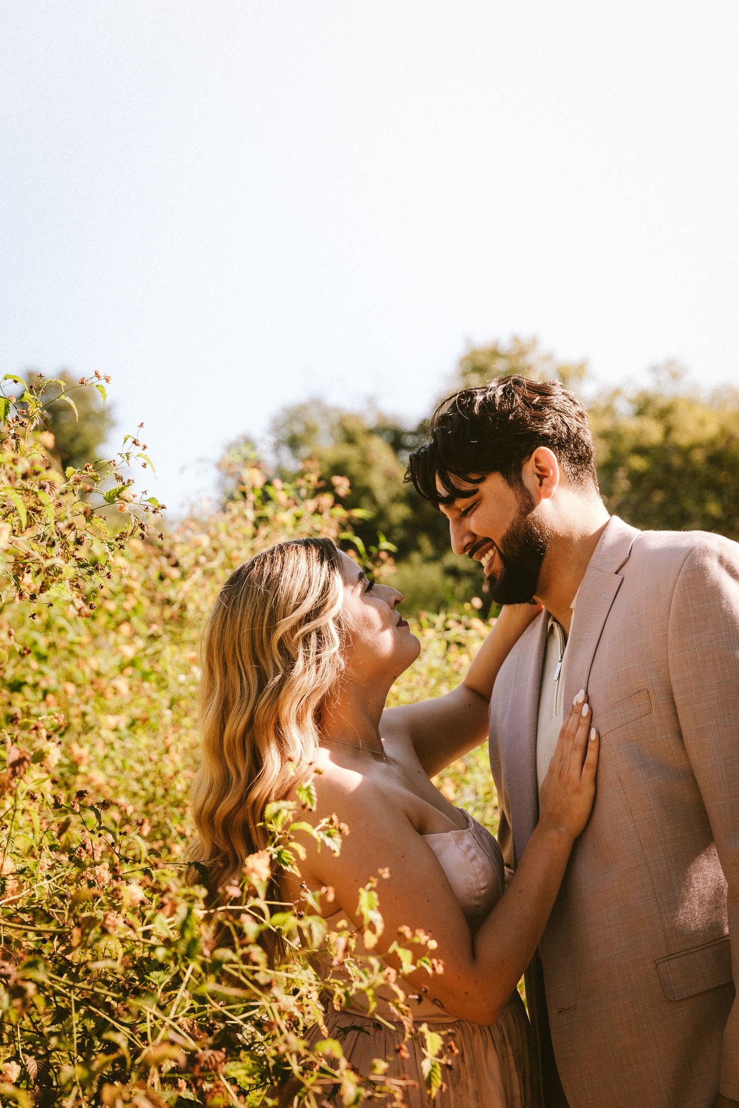 A romantic moment photographed among wildflowers during golden hour.