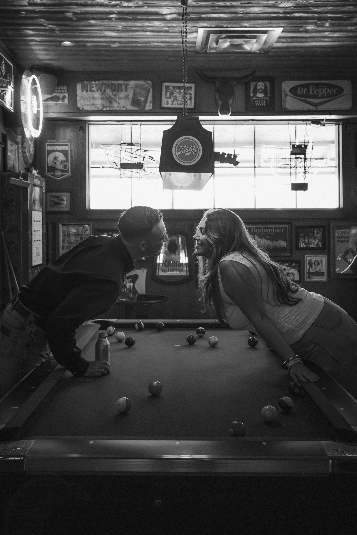 Black and white photos show a dark billiards room with regulation pool tables and dimly lit neon signs on the walls.