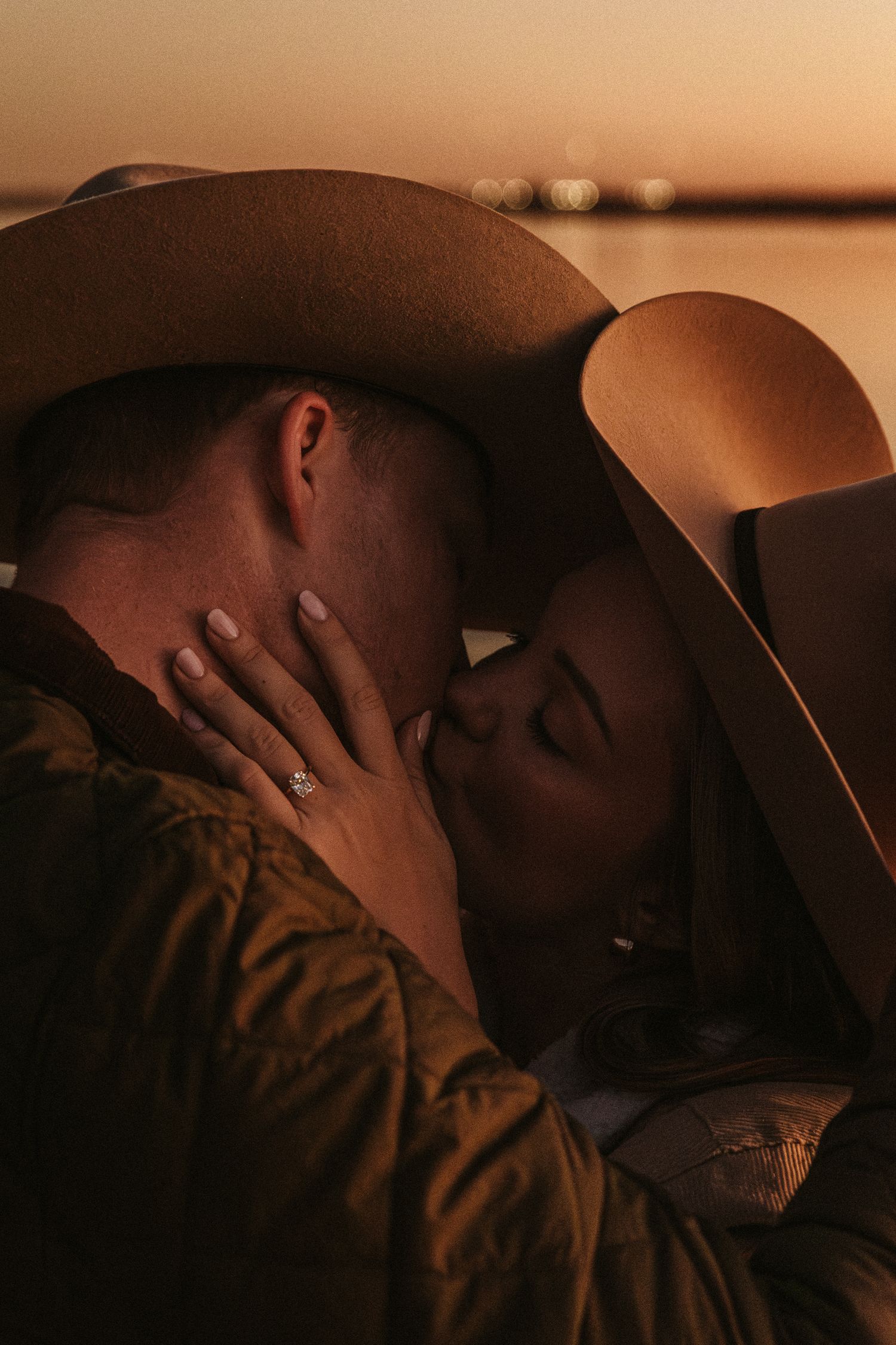 Romantic close-up portrait of a couple embracing in golden sunset lighting.
