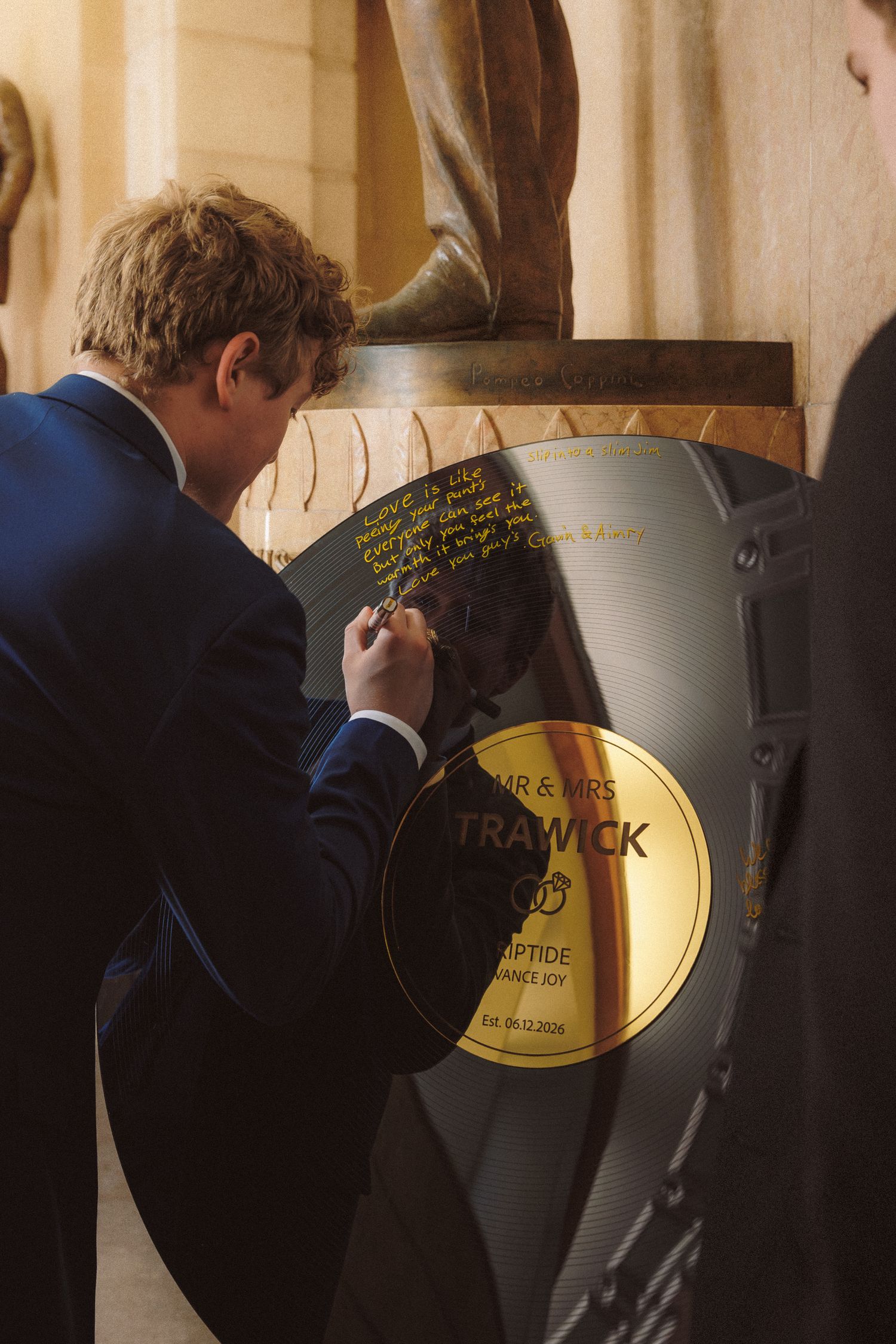 Wedding guest signing custom vinyl record guest book labeled Mr and Mrs Trawick at reception.
