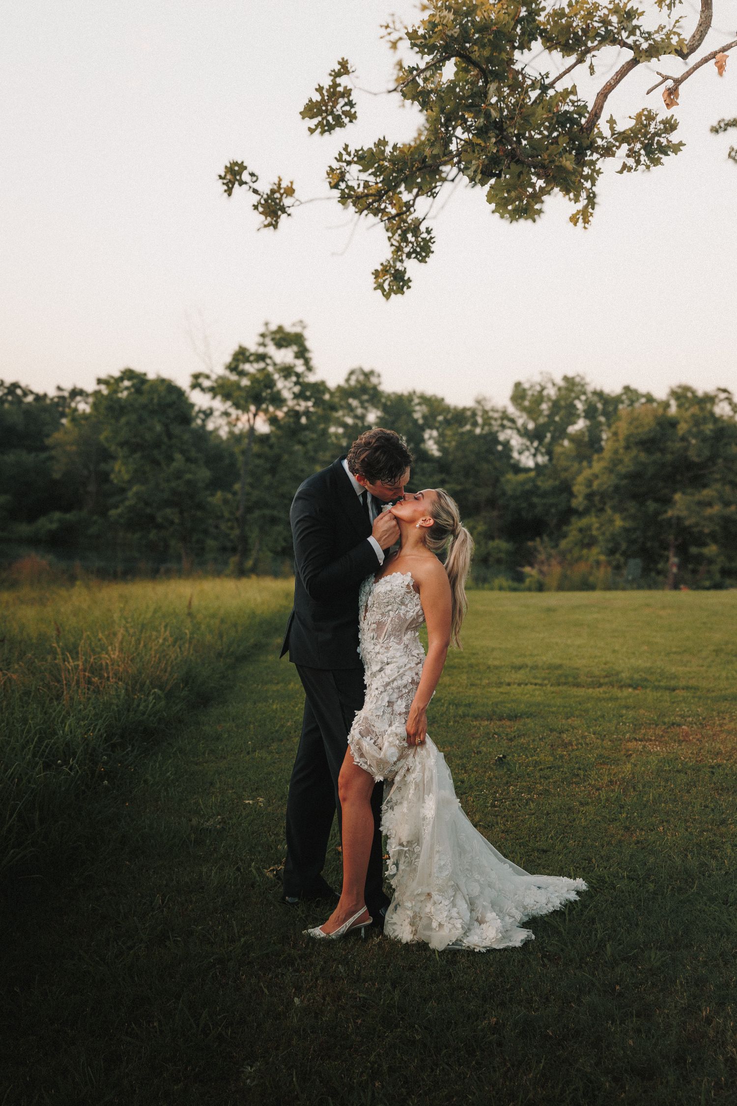 Romantic sunset dance in a meadow during wedding photo session.