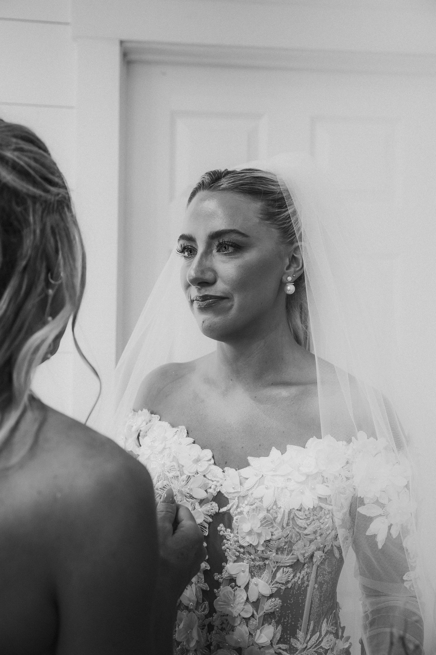 Elegant lace wedding dress details captured in black and white photography.