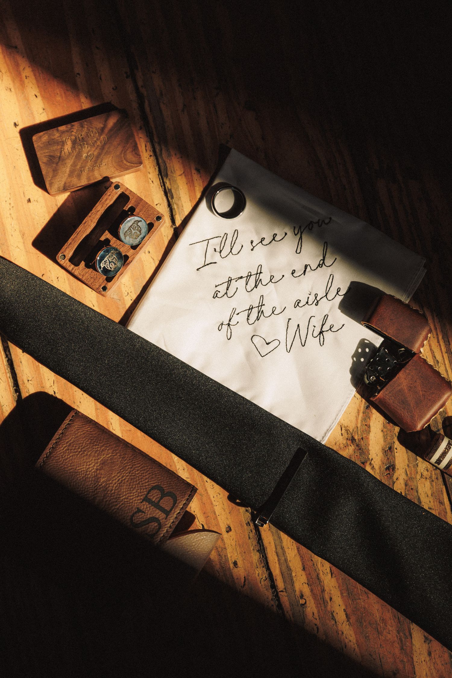 Groom's wedding day flat lay with black tie, watch, and handwritten note reading I'll see you at the end of the aisle.