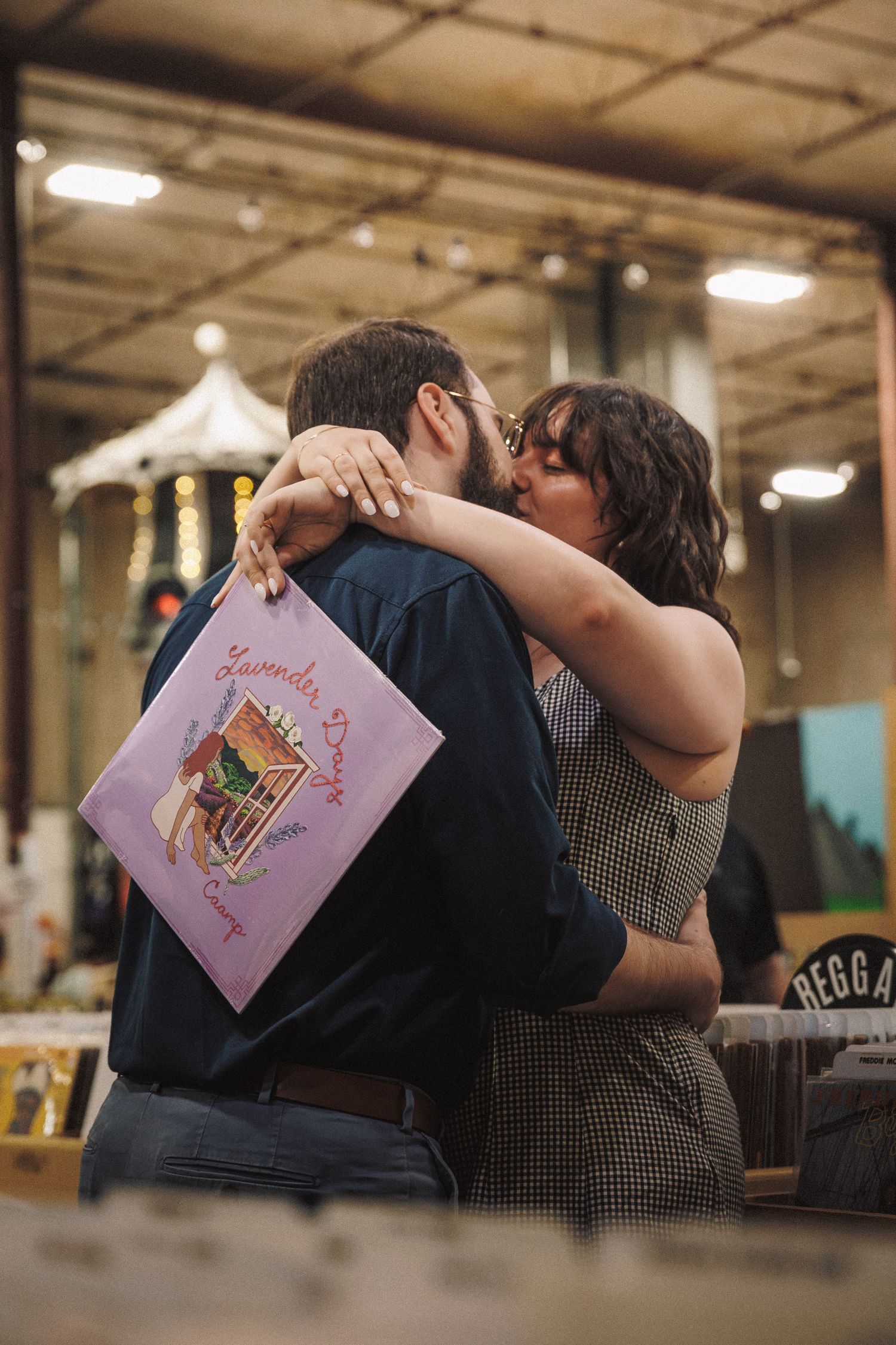 Couple reading pink greeting cards together in romantic indoor setting with warm lighting.