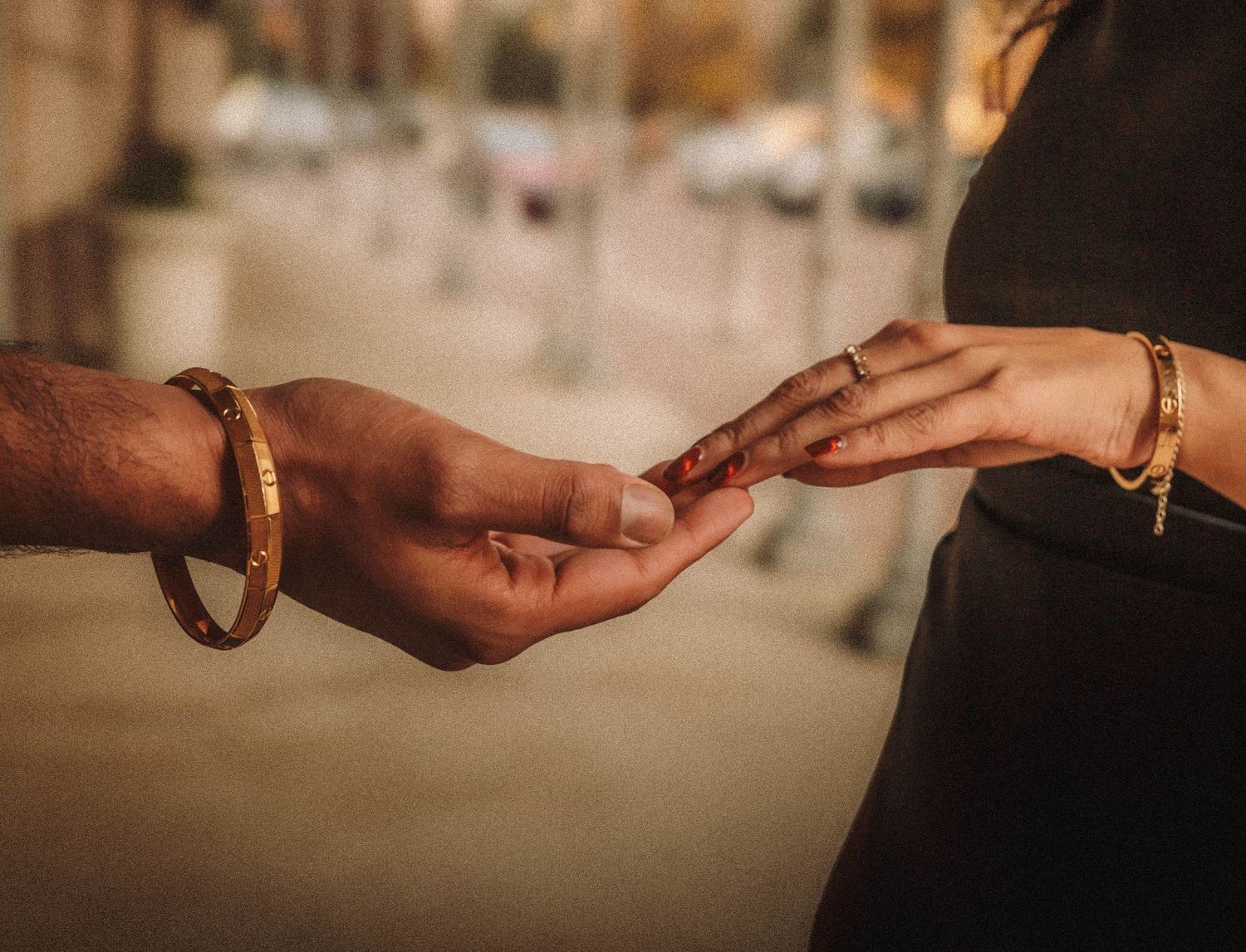 Close-up shots showing a series of hands exchanging a small object in warm lighting.