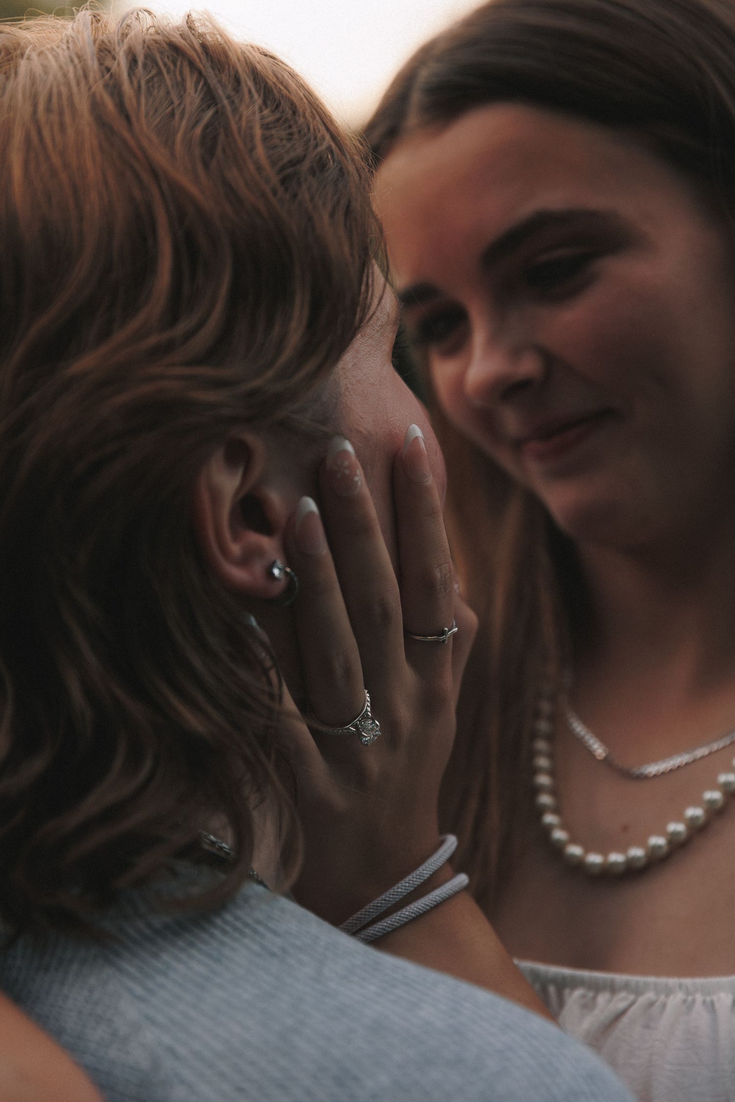 Close-up shot showing pearl necklace and jewelry details during an intimate moment.