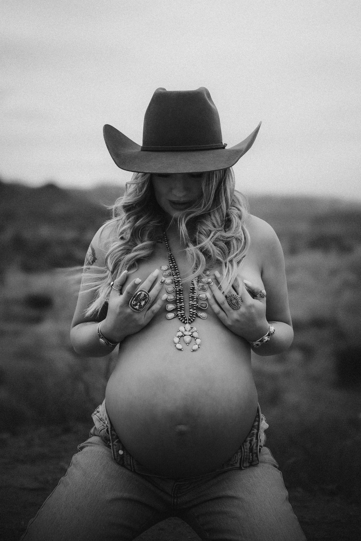 Black and white maternity photos show silhouette in cowboy hat against landscape backdrop in artistic style.