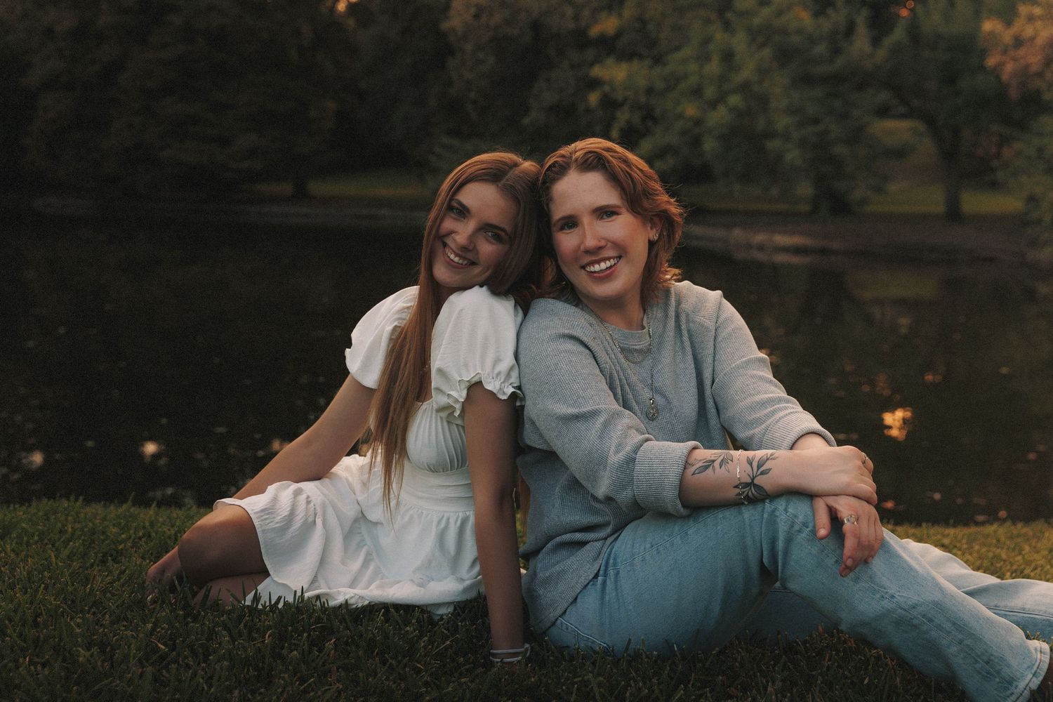 Couple relaxing together in a park at dusk with warm lighting.