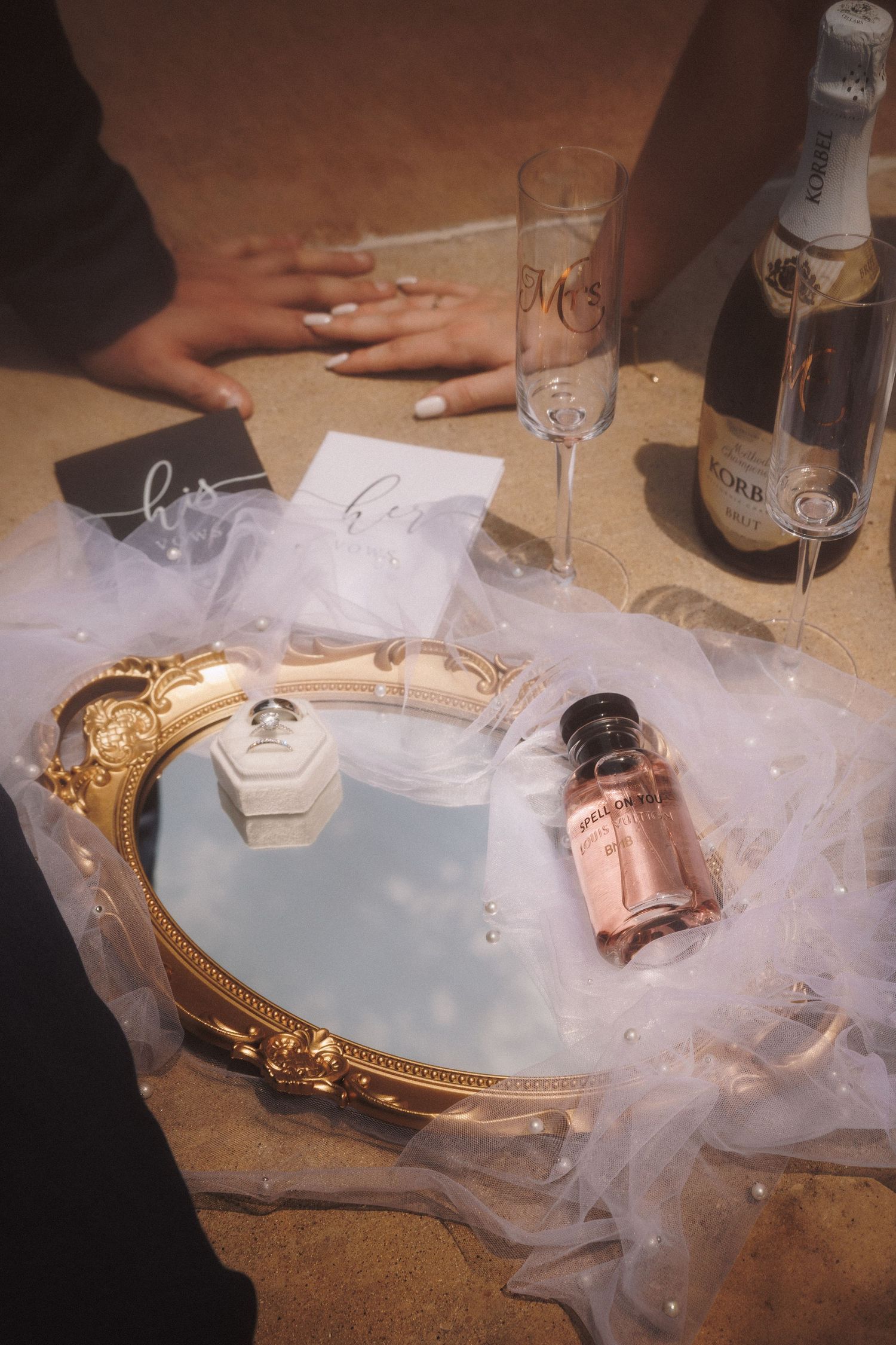 Sequence of photographs showing a gold necklace revealed through delicate layers of tulle or organza fabric on a table.