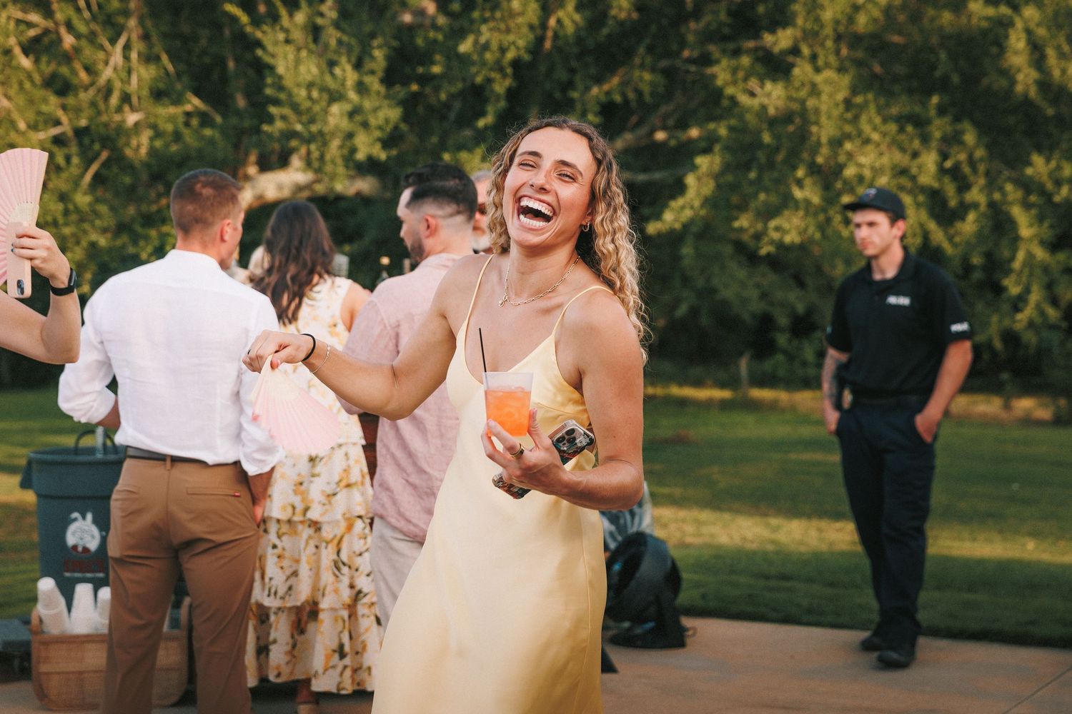 Wedding guests dancing and celebrating at outdoor evening reception.