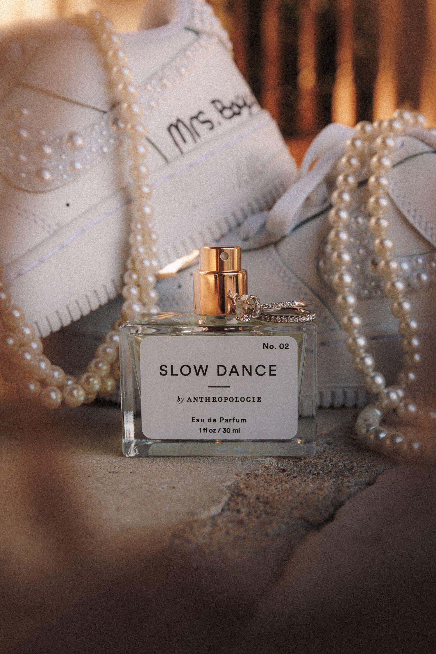 Slow Dance by Anthropologie No. 02 Eau de Parfum bottle with pearl necklace and bridal sneakers reading I Mrs.